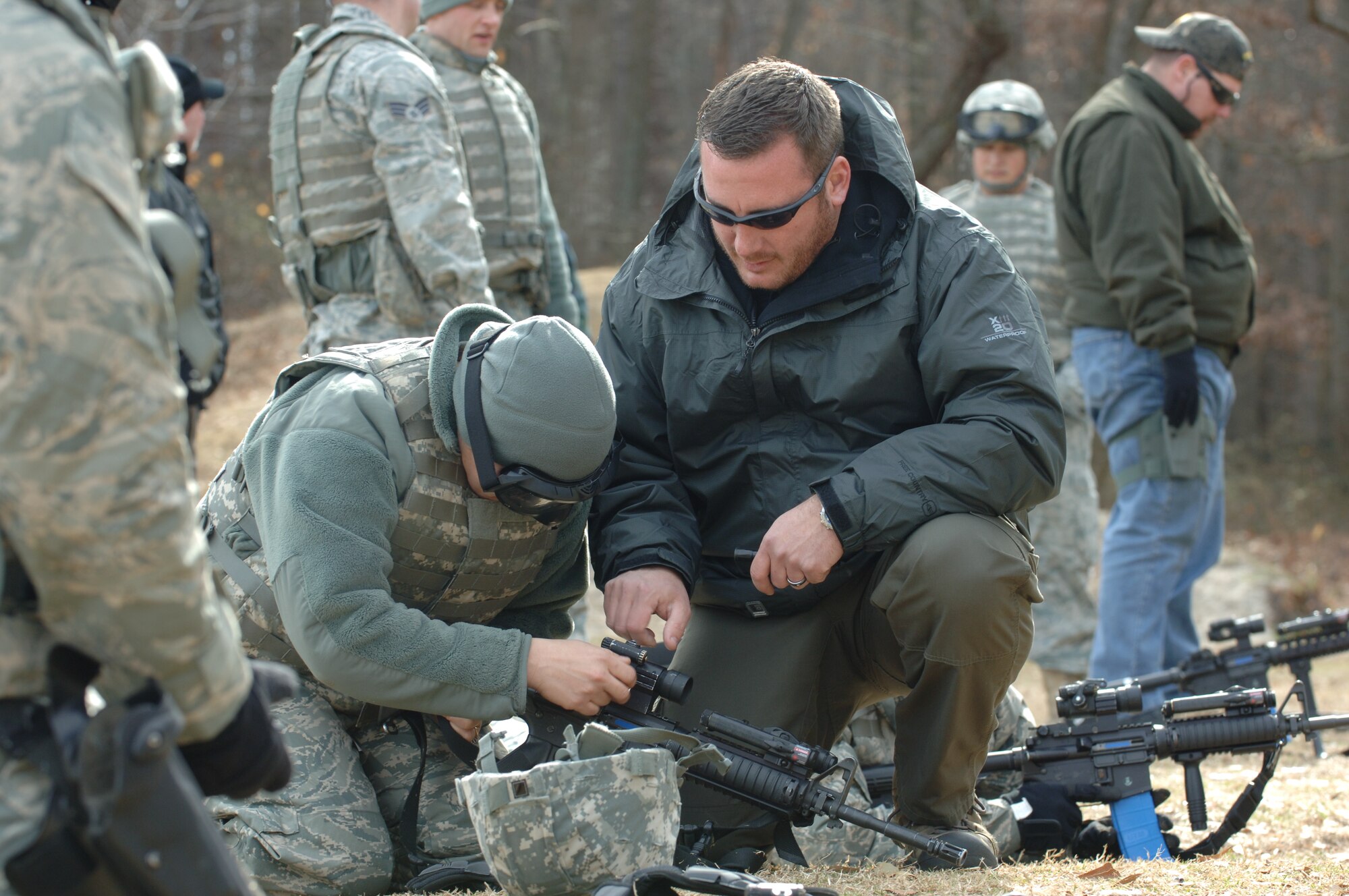 LANGLEY AIR FORCE BASE, Va. -- Eric Seto, Ultimate Training Munitions training manager, assists 633d Security Forces Squadron Airmen in loading UTM training ammunition into M4 assault rifles during UTM ballistics training at Bethel Park Feb. 3. UTM rounds allow combat arms trainers to “get in front of the weapon,” to observe operator mechanics such as trigger pull, weapon handling and clearing malfunction drills. (U.S. Air Force photo/Airman 1st Class Jason J. Brown) (RELEASED)