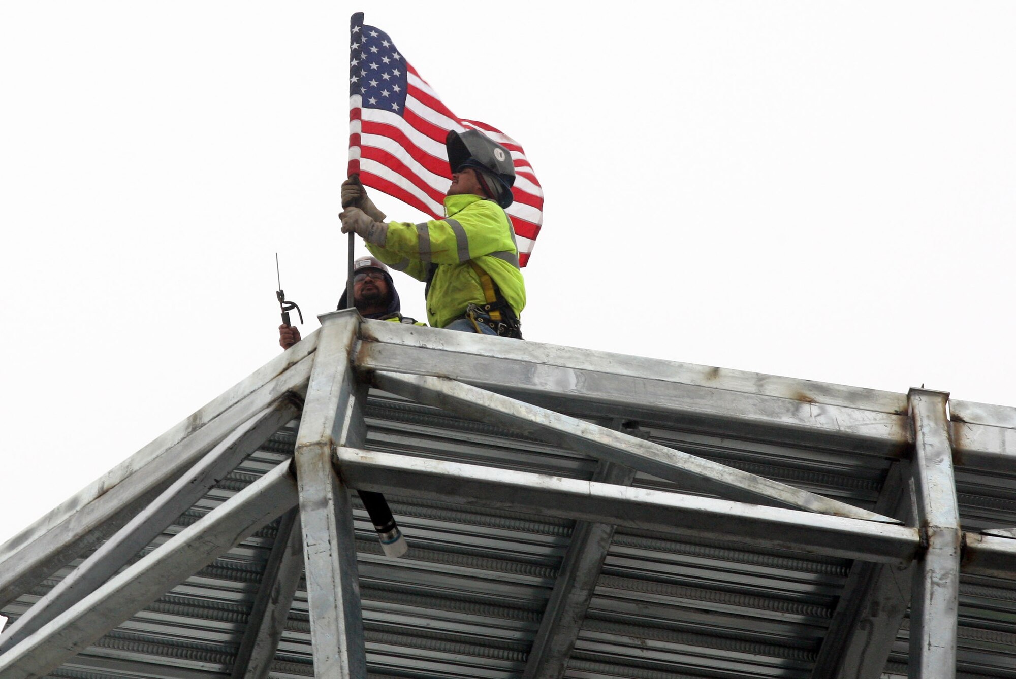 Construction crews mount the flag at the top of the newly placed tower cab frame Feb 1. (U.S. Air Force Photo/Don Peek)
