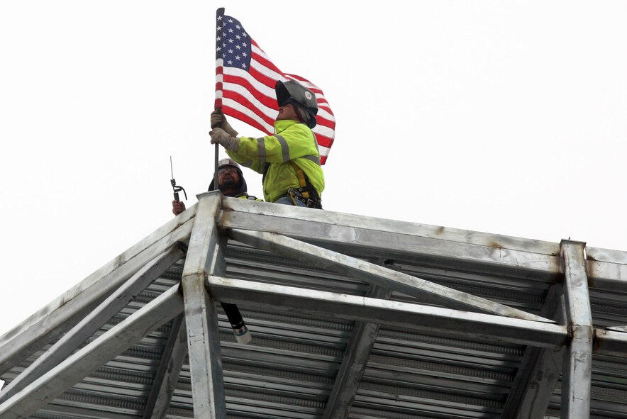 Construction crews place the flag at the top of the new tower cab frame Feb. 1. (U.S. Air Force Photo/Don Peek) 
