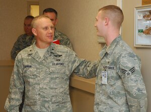LANGLEY AIR FORCE BASE, Va. – Brig. Gen. Daniel Wyman, Air Combat Command surgeon general, congratulates Senior Airman Bryan Ross, 633d Dental Squadron dental lab technician, Feb. 3, for his outstanding work at the USAF Hospital Langley Dental Clinic General Wyman toured the newly renovated hospital to examine operations and acknowledge outstanding performers within the 633d Medical Group.  (U.S. Air Force photo/Airman 1st Class Elizeu) (Released)