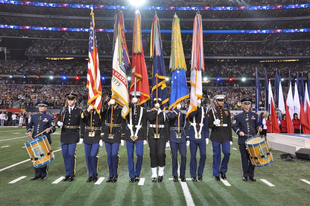 MSgt Chris Martin and TSgt Nathan Lavy of the U.S. Air Force Band Ceremonial Brass perform with a joint-service color team at Super Bowl XLV. 