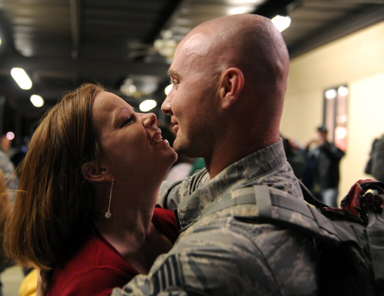 MOODY AIR FORCE BASE, Ga.-- Staff Sgt. Charles Woods, 723rd Aircraft Maintenance Squadron electronic warfare systems journeyman,  hugs Sarah Howard after exchanging a kiss upon returning from a deployment Feb. 8. Moody personnel were greeted by their loved ones after being deployed to Southwest Asia for more than four months. (U.S. Air Force photo/Airman 1st Class Benjamin Wiseman)(RELEASED)