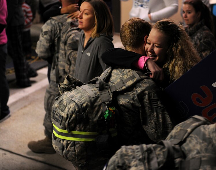 MOODY AIR FORCE BASE, Ga.-- Staff Sgt. Alexander Alexander, 23rd Equipment Maintenance Squadron aircraft structure technician, hugs his wife, Kimber, as they are joined back together after a four-month wait Feb. 8. Members from the 23rd Maintenance Group were responsible for ensuring combat search and rescue aircrafts deployed to Joint Base Balad, Iraq, were safe, reliable and serviceable. (U.S. Air Force photo/Airman 1st Class Benjamin Wiseman)(RELEASED)