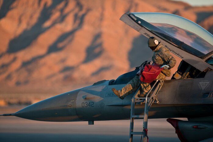 NELLIS AIR FORCE BASE, Nev.--Airman 1st Class Loren Simon, 480th Aircraft Maintenance Squadron crew chief, from Spangdahlem Air Base Germany, removes the seat cover of an F-16 Fighting Falcon while completing pre-flight checks during Red Flag 11-2 Feb. 2. Red Flag is a realistic combat training exercise involving the air forces of the United States and its allies. (U.S. Air Force photo by Tech. Sgt. Michael R. Holzworth)
