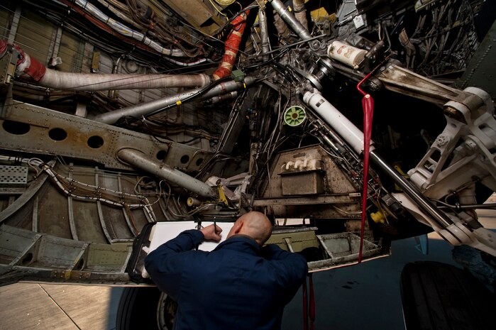 NELLIS AIR FORCE BASE, Nev. -- Staff Sgt. Anthony Charon, 2nd Aircraft Maintenance Squadron crew chief, from Barksdale Air Force Base La., signs  maintenance forms while inside a wheel well of a B-52 Stratofortress during Red Flag 11-2 Jan. 26. Red Flag is a realistic combat training exercise involving the air forces of the United States and its allies. (U.S. Air Force photo by Tech. Sgt. Michael R. Holzworth)