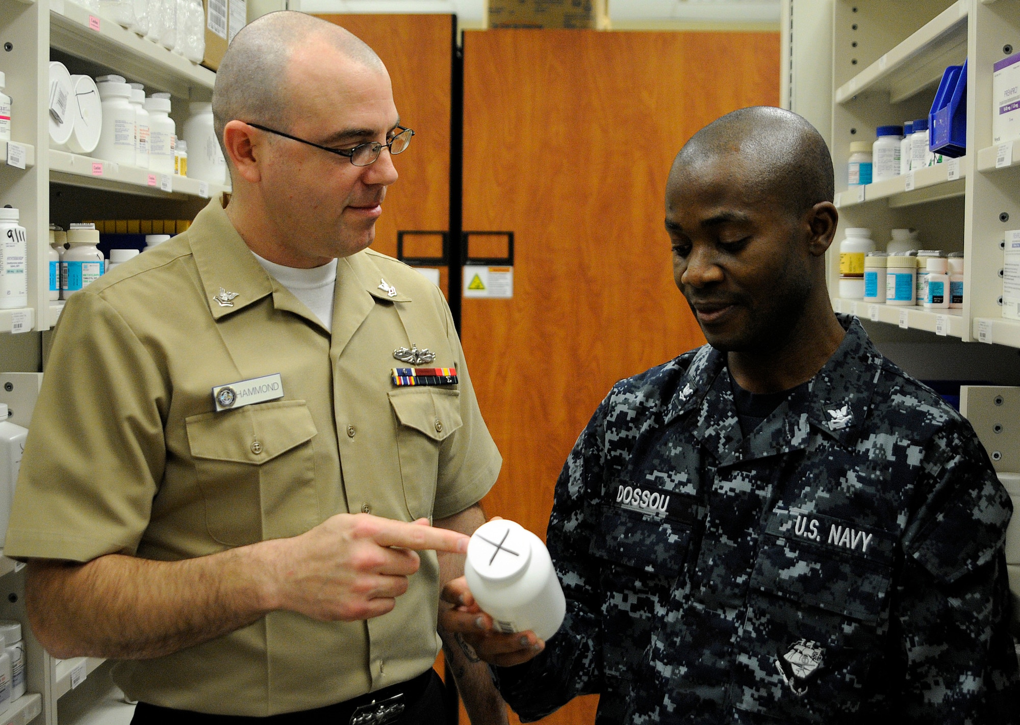 Hospital Corpsman 2nd Class Andrew Hammond (left) instructs Hospital Corpsman 3rd Class Ben Dossou on the procedures for filling a prescription at Naval Health Clinic Charleston pharmacy department at Joint Base Charleston-Weapons Station, Jan. 28. HM2 Hammond was selected as the Sailor of the Quarter for the fourth quarter of fiscal year 2010.  (U.S. Navy photo/Machinist’s Mate 3rd Class Brannon Deugan)