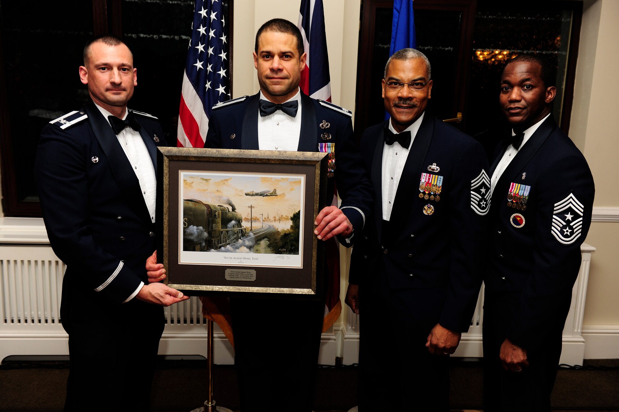 RAF ALCONBURY, United Kingdom - Lt. Col. Jose Rivera accepts the Company Grade Officer of the Year Award on behalf of Capt. Jeffery Brandenburg during the 501st Combat Support Wing Annual Awards Ceremony Feb. 4 at RAF Alconbury. Captain Brandenburg, who is assigned to the 422nd Civil Engineer Squadron, is currently deployed. (U.S. Air Force photo by Tech. Sgt. John Barton)