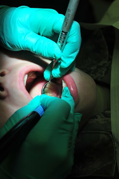 MINOT AIR FORCE BASE, N.D. – Staff Sgt. Jessica Maxfield, 5th Medical Group dental technician, cleans the teeth of Senior Airman Samantha Smith, 5th Maintenance Squadron non-destructive inspection apprentice, during a routine cleaning here Jan. 26. The mission of the 5th MDG is to ensure base Airmen are dentally qualified to deploy. (U.S. Air Force photo/ Senior Airman Jesse Lopez)