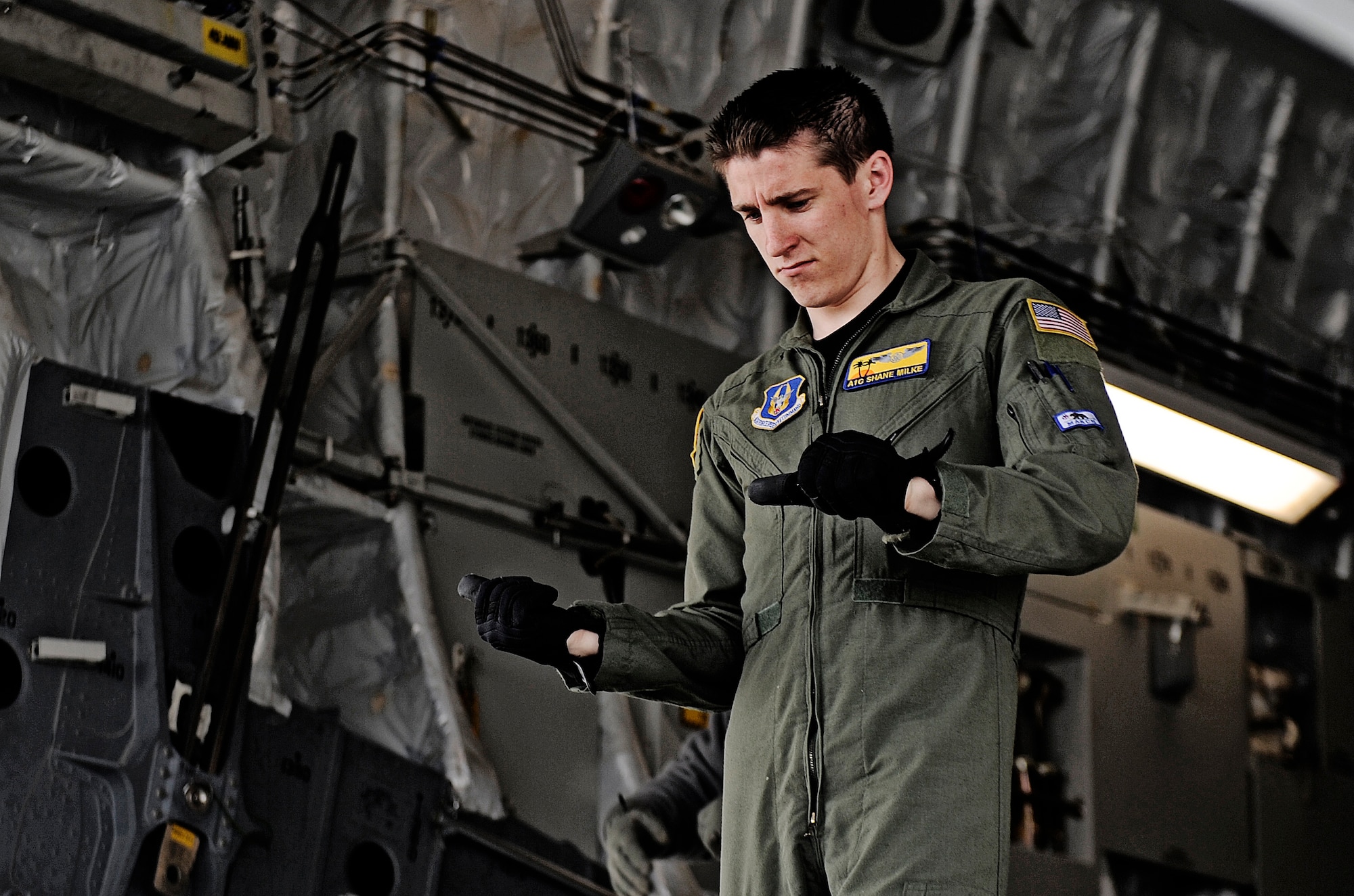 Airman 1st Class Shane Milke, 452nd Air Mobility Wing loadmaster, directs the cargo truck operator where to position the loader behind the C-17 Globemaster Feb. 7, 2011 at Scott Air Force Base.  6,545 pounds of humanitarian goods including three pallets of clothing and shoes donated from Red Bud, Ill.  are being transferred to Manas, Kyrgyzstan before arriving at the final location in Afghanistan.  (U.S. Air Force photo/ Staff Sgt. Ryan Crane)