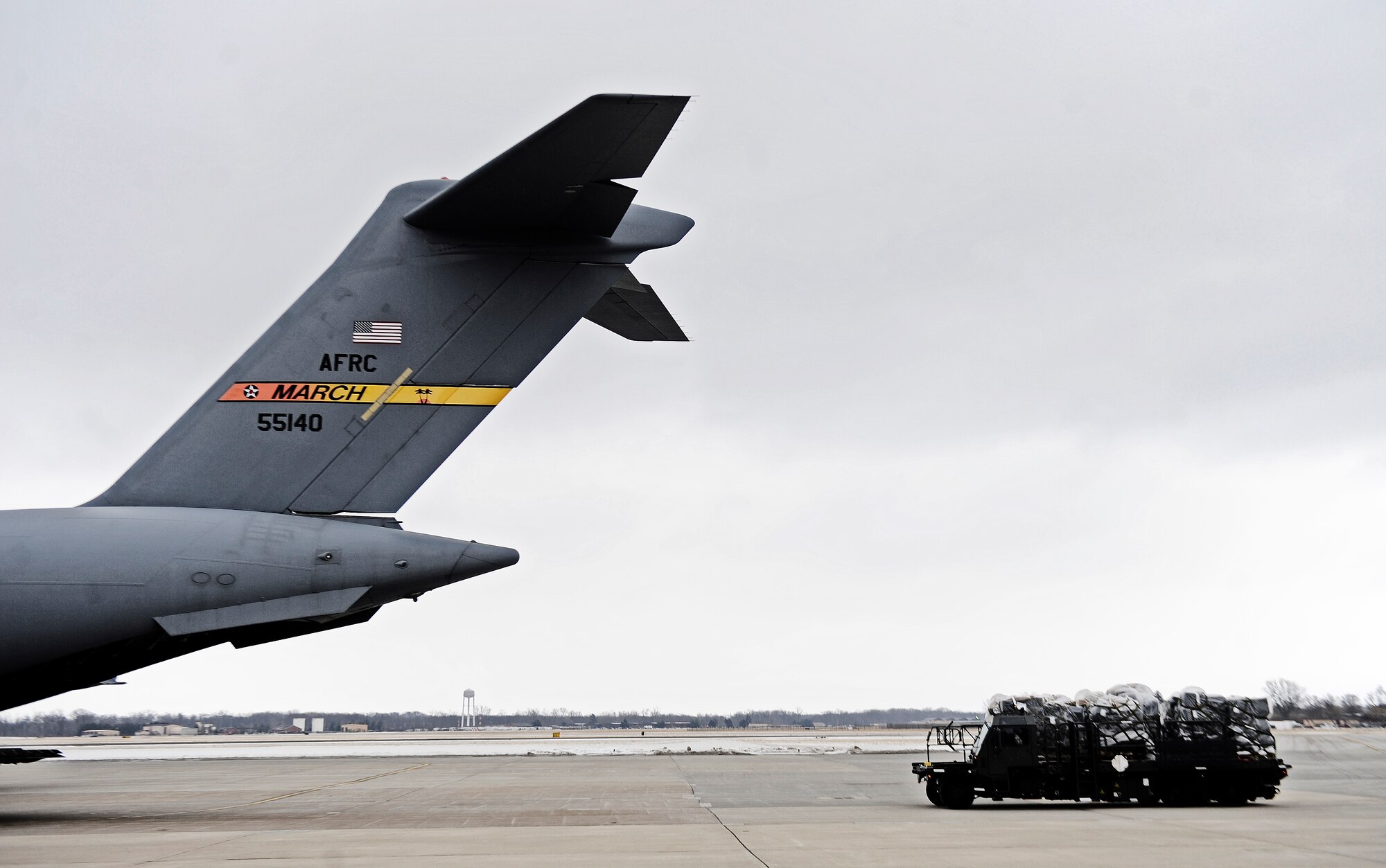 A cargo truck from the 375th Logistics Readiness Squadron pulls up behind a C-17 Globemaster to load humanitarian aid supplies bound for Afghanistan, Feb. 7, 2011 at Scott Air Force Base. 6,545 pounds of humanitarian goods including three pallets of clothing and shoes donated from Red Bud, Ill.  are being transferred to Manas, Kyrgyzstan before arriving at the final location in Afghanistan. (U.S. Air Force photo/ Staff Sgt. Ryan Crane)