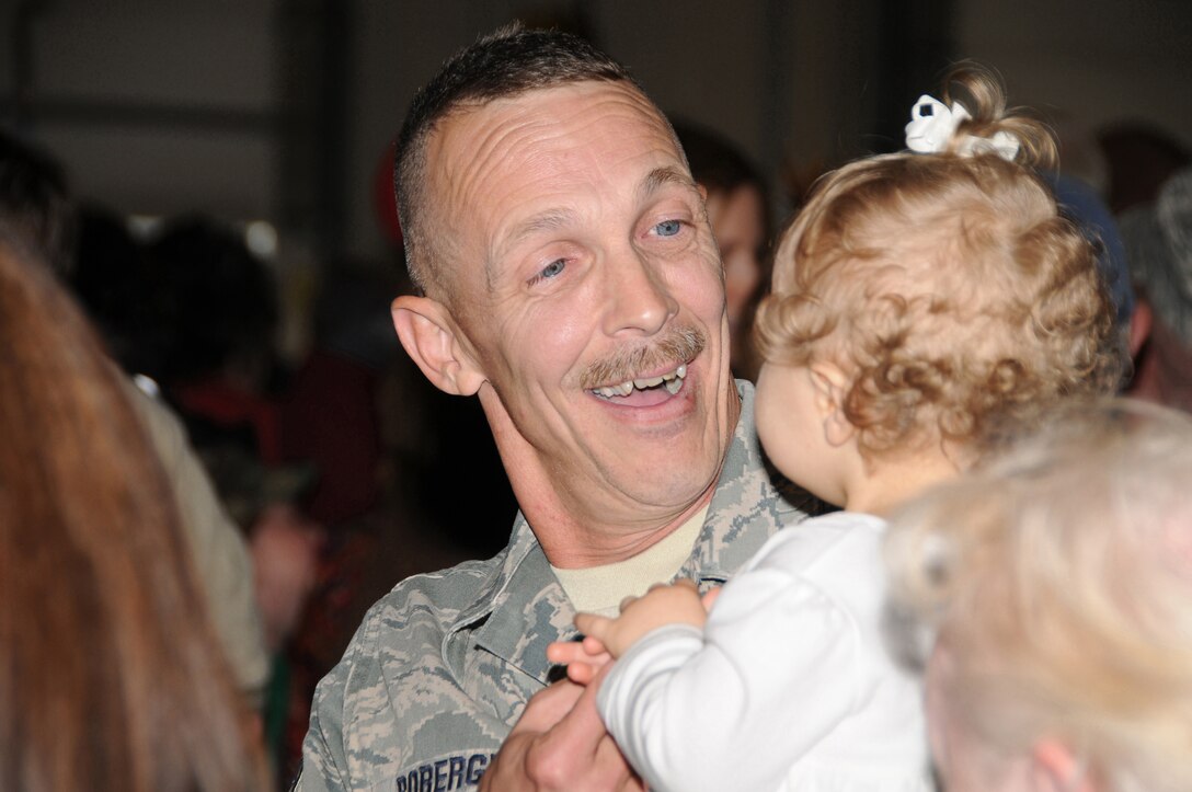 Senior Master Sergeant John Roberge reunites with his family during a return ceremony. The 158th Fighter Wing Security Forces deployed to Saudi Arabia for 6 months and returned November, 2010.