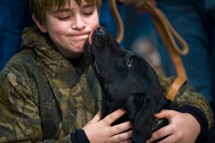 Brady Rusk, 12, hugs Eli, a bomb-sniffing military working dog, during a retirement and adoption ceremony Feb. 3, 2011, at Lackland Air Force Base, Texas. The Labrador retriever was assigned to Brady's older brother, Marine Pfc. Colton Rusk who was killed Dec. 5 in Afghanistan by Taliban sniper fire. Department of Defense officials granted the Rusk family permission to adopt Eli following his “retirement from the U.S. Marine Corps.” (U.S. Air Force photo/Tech. Sgt. Bennie J. Davis III) 
