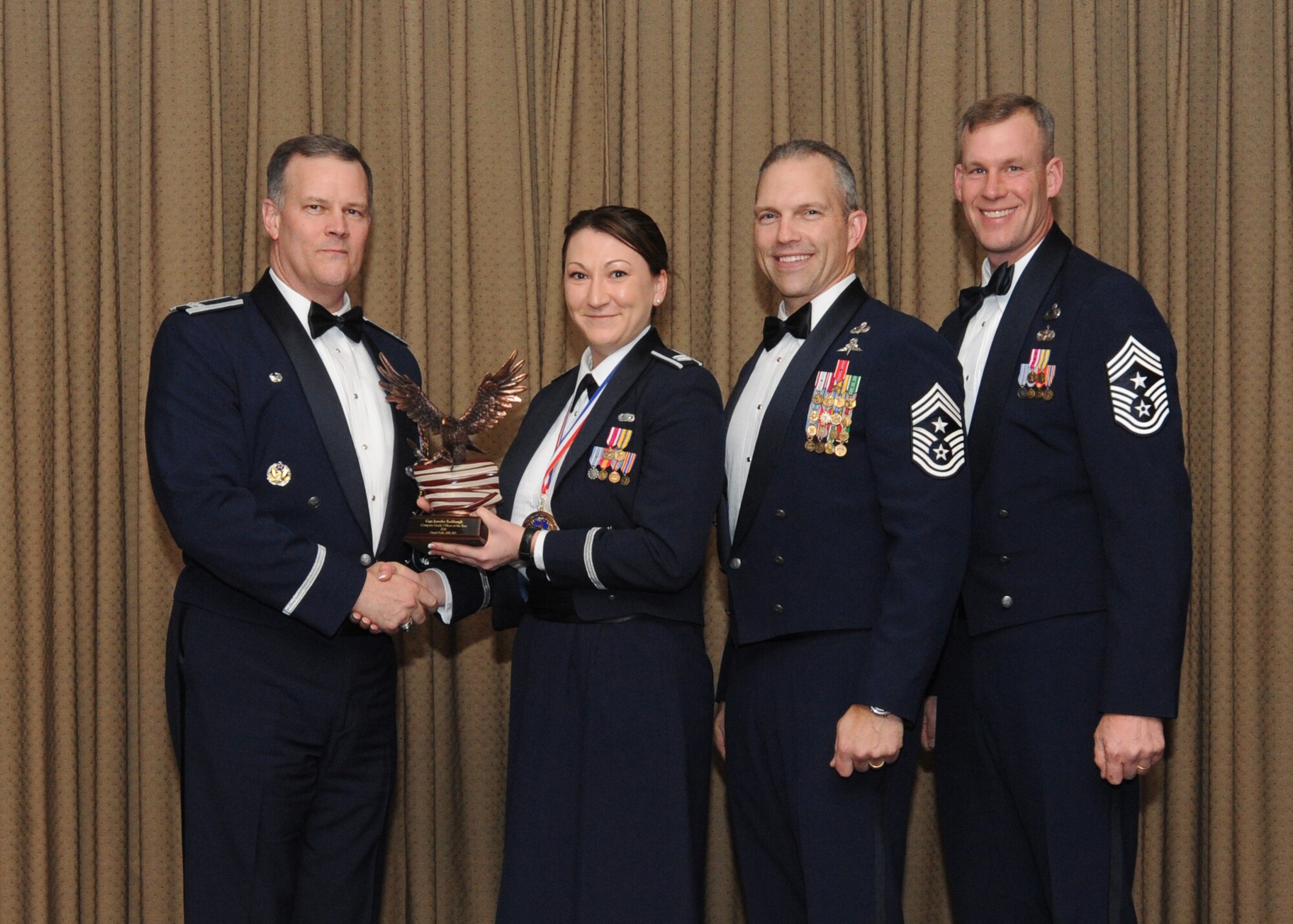 Capt. Jennifer Eshbaugh, 319th Force Support Squadron, is presented with the 2010 Company Grade Officer of the Year award for Grand Forks Air Force Base Feb. 4 at the Northern Lights Club. Presenting the award is Col. Don Shaffer, 319th Air Refueling Wing commander, along with Command Chief Master Sgt. Martin Klukas, Air Combat Command, and Command Chief Master Sgt. David Carlson, 319th Air Refueling Wing. (U.S. Air Force photo by Staff Sgt. Suellyn Nuckolls)