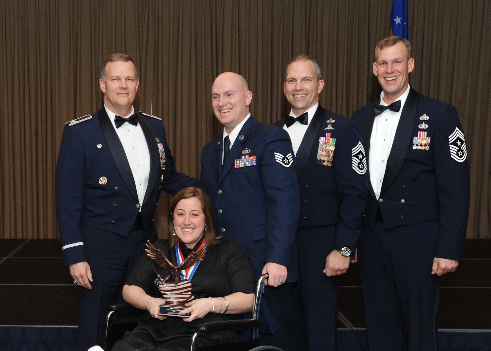 Jamie Ledoux is presented with the 2010 Category One Civilian of the Year award for Grand Forks Air Force Base Feb. 4 at the Northern Lights Club. Presenting the award is Col. Don Shaffer, 319th Air Refueling Wing commander, along with Jamie’s husband, Staff Sgt. David Ledoux, 319th Operations Support Squadron; Command Chief Master Sgt. Martin Klukas, Air Combat Command; and Command Chief Master Sgt. David Carlson, 319th Air Refueling Wing. (U.S. Air Force photo by Staff Sgt. Suellyn Nuckolls)