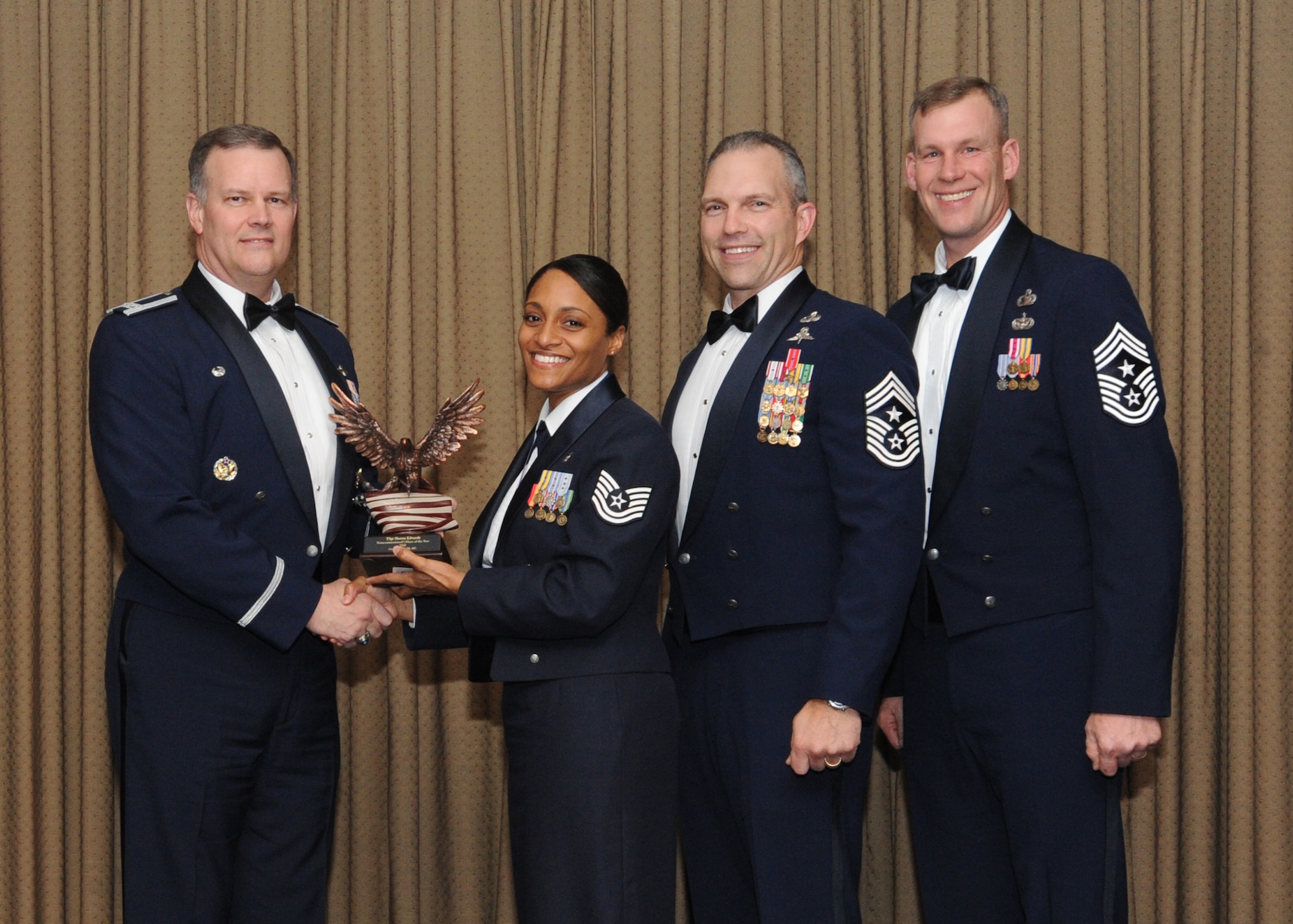 Tech. Sgt. Sheena Edwards, 319th Medical Support Squadron, is presented with the 2010 Non-commissioned Officer of the Year award for Grand Forks Air Force Base Feb. 4 at the Northern Lights Club. Presenting the award is Col. Don Shaffer, 319th Air Refueling Wing commander, along with Command Chief Master Sgt. Martin Klukas, Air Combat Command, and Command Chief Master Sgt. David Carlson, 319th Air Refueling Wing. (U.S. Air Force photo by Staff Sgt. Suellyn Nuckolls)