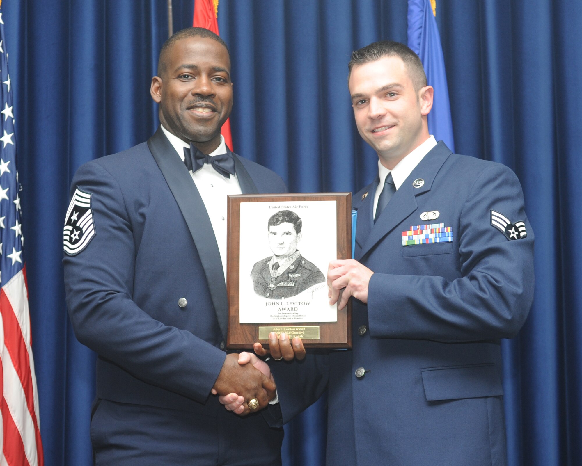 Chief Master Sgt. Marcus Snoddy, the 39th Air Base Wing command chief, presents the John L. Levitow Award to Senior Airman Neil Kozak, from the 39th Operations Squadron, during the Airman Leadership School graduation for class 11-3 at the consolidated club Feb. 4, at Incirlik Air Base, Turkey. The Levitow Award is the pinnacle achievement for enlisted Airmen enrolled in professional military education in the U.S. Air Force. It is awarded to the top graduate at each level of PME: ALS, NCO academy and Senior NCO Academy. There is only one Levitow Award given in each class. (U.S. Air Force photo by Airman 1st Class Clayton Lenhardt/Released)