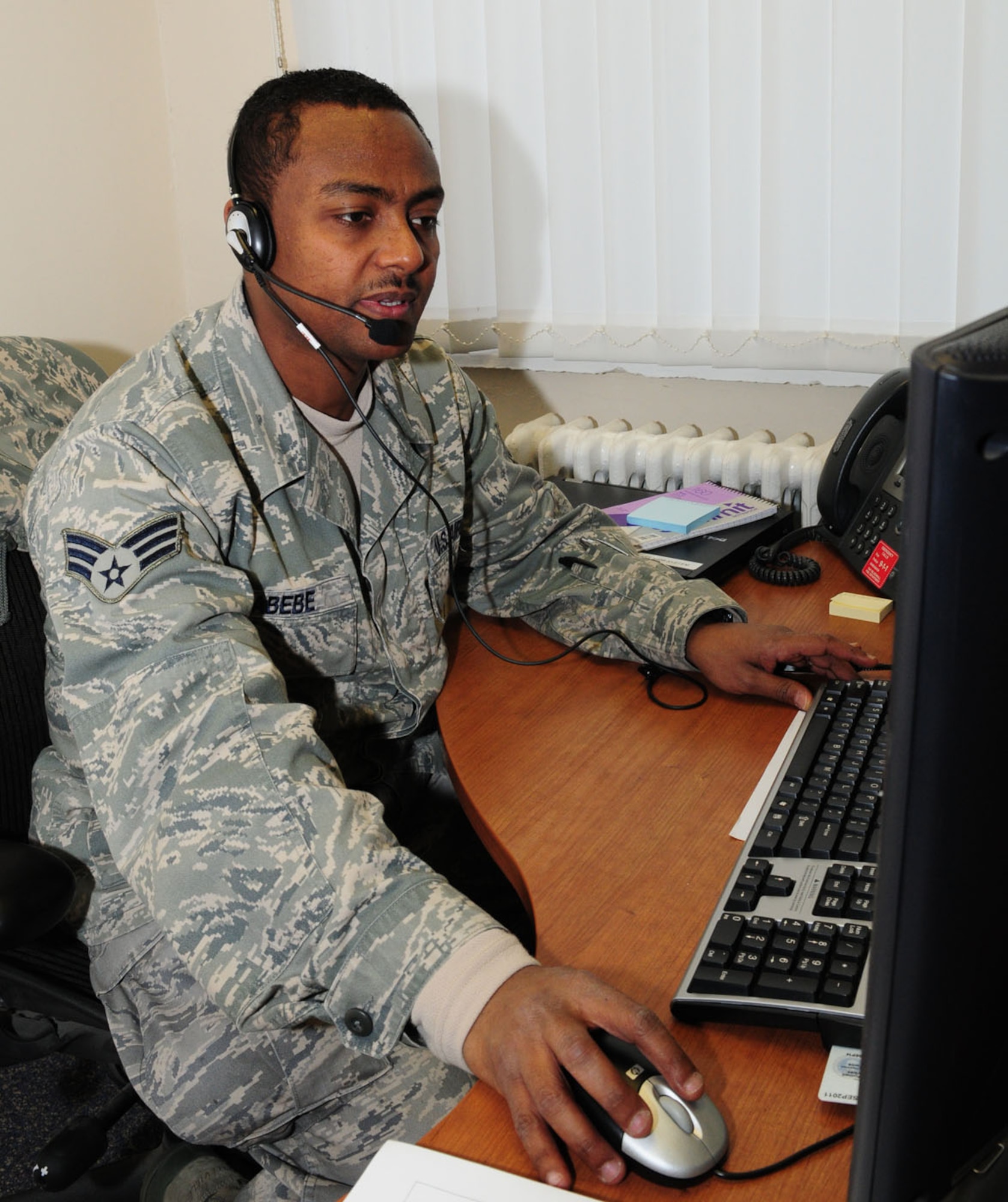 RAF MILDENHALL, England -- Senior Airman Melaku Abebe, 100th Communications Squadron Client Services Center technician, talks to a customer as he remotely accesses their computer to fix a problem. Airman Abebe is one of many technicians forming three teams, who help customers both remotely and face-to-face, depending on the computer problem. To open a trouble ticket for network-related issues, call DSN 478-4357. For non-network related issues, call DSN 238-2666. (U.S. Air Force photo/Karen Abeyasekere)
