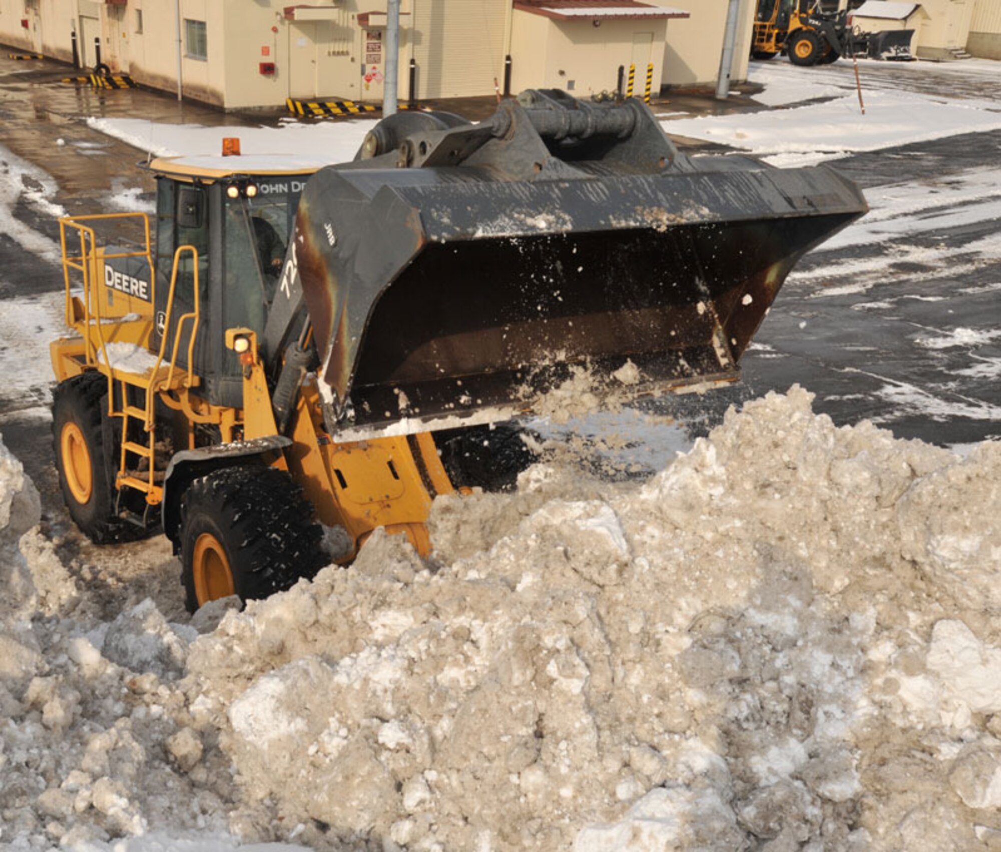 U.S. Air Force Airman 1st Class Brandon Hotopp, 35th Civil Engineer Squadron snow removal team member, clears a parking lot Feb. 8, 2011, at Misawa Air Base, Japan. February snowfall totals in Misawa can exceed 30 inches. (U.S. Air Force photo by Airman James B. Bauer/Released)