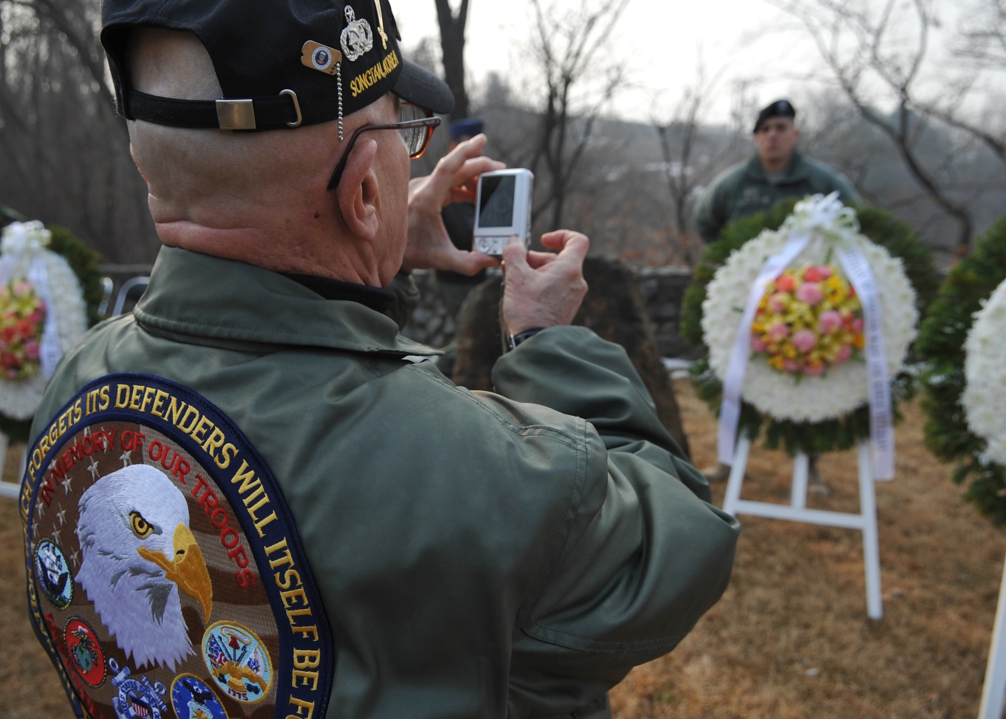 A veteran takes pictures at the memorial during the 60th Anniversary "Battle of Hill 180” ceremony Feb. 8 at Osan Air Base, Republic of Korea. The ceremony paid tribute to the actions of the Soldiers of the 27th Infantry Regiment "Wolfhounds" during a bayonet charge up Hill 180 here Feb. 7, 1951. (U.S. Air Force photo/Senior Airman Evelyn Chavez)