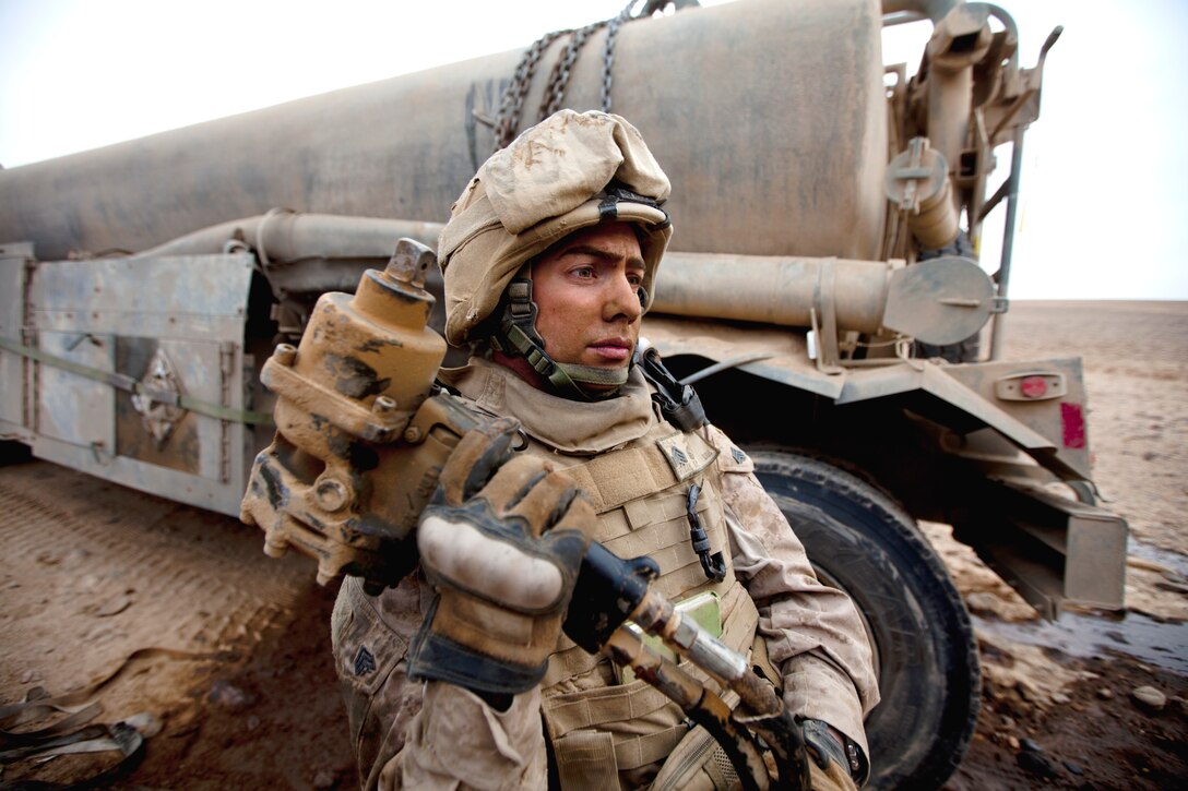 U.S. Marine Corps Sgt. Michael Fryman prepares to change the tires on ...