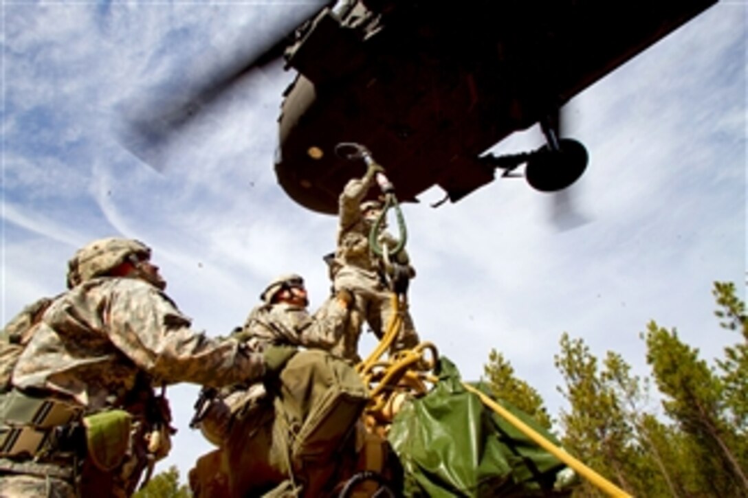 U.S. Army paratroopers sling load an M119A2 105 mm howitzer to a UH-60M Black Hawk helicopter during air assault training at Fort Bragg, N.C., on Feb. 2, 2011.  