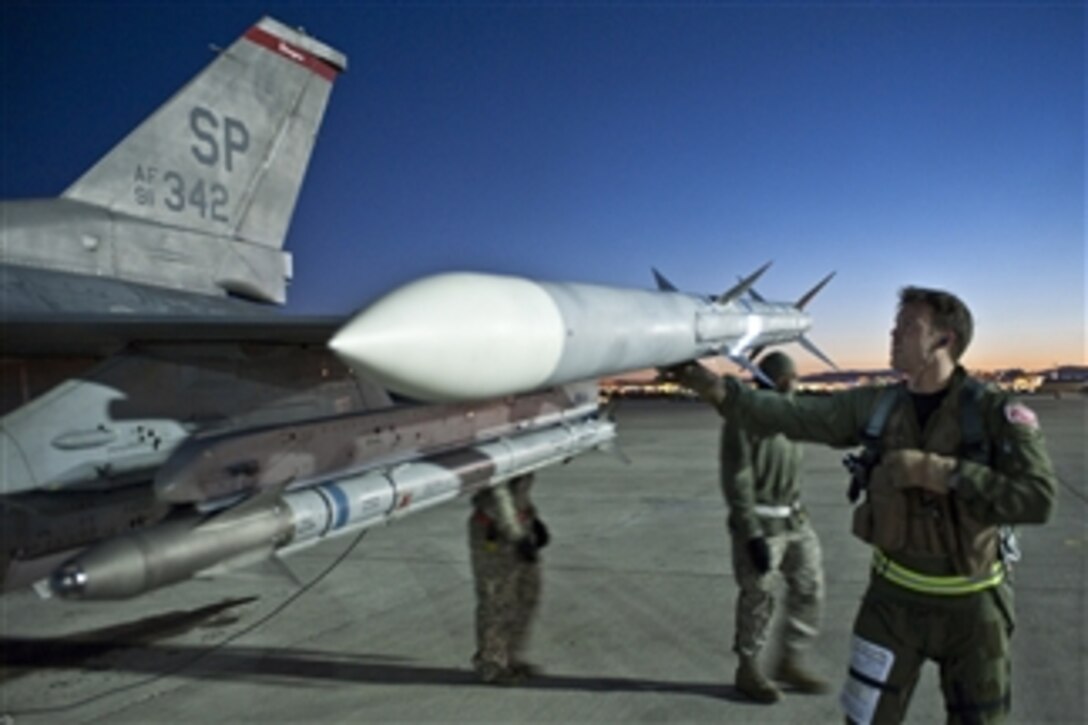 U.S. Air Force Capt. Brian Morrissey (right), a pilot assigned to the 480th Fighter Squadron, Spangdahlem Air Base, Germany, conducts preflight checks on an F-16 Fighting Falcon aircraft before a night training mission at Nellis Air Force Base, Nev., during Red Flag 11-2 on Feb. 2, 2011.  Red Flag is a combat training exercise involving the air forces of the United States and its allies.  