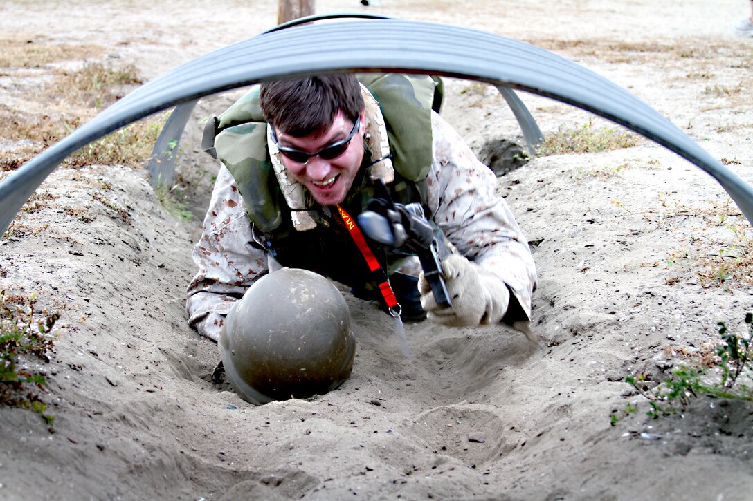 Brian Deatherage, biology teacher, Kuna High School, Kuna, Idaho, keeps positive control of his weapon and his Kevlar helmet while crawling through a tunnel during the bayonet assault course, here, Feb. 08. Deatherage was among the 83 educators from Recruiting Stations Portland, Ore., and Salt Lake City visiting the depot this week, to learn what students who join the Marine Corps can expect from recruit training.