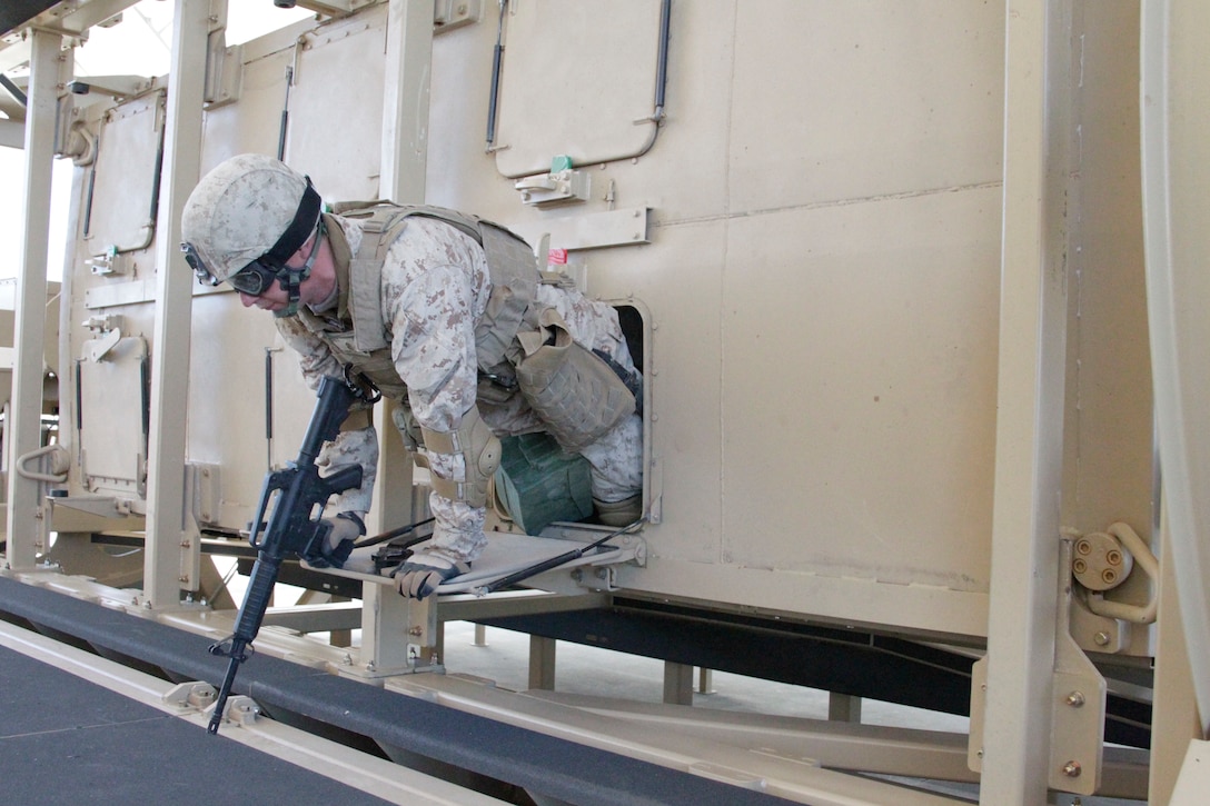 Marines with 2nd Combat Engineer Battalion from Marine Corps Base Camp Lejuene, N.C., exit the Mine Resistant Ambush Protected (MRAP)  Egress Trainer, a roll-over simulator at the Battle Simulation Center in Camp Wilson Feb. 9, 2011.::r::::n::