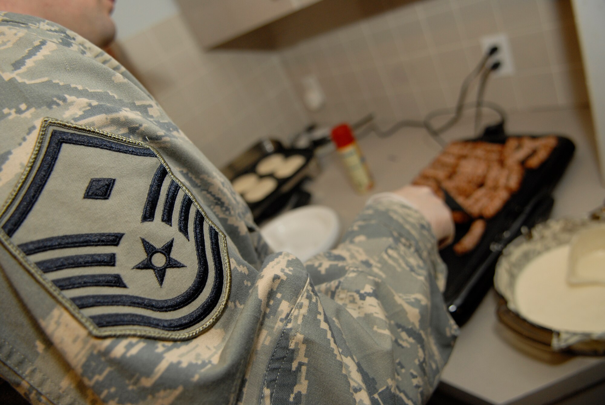 VANDENBERG AIR FORCE BASE, Calif. -- Master Sgt. Chris Howard, the 9th Air and Space Operations Squadron first sergeant, cooks sausages during the 1st Sgt.'s Council Pancake Breakfast event at the Airman and Family Readiness Center here Friday, Feb. 4, 2011.  The 1st Sgt.'s Council held the event to raise money for the Vandenberg Food Pantry, which helps the base community.  (U.S. Air Force photo/Senior Airman Andrew Satran) 

 
 