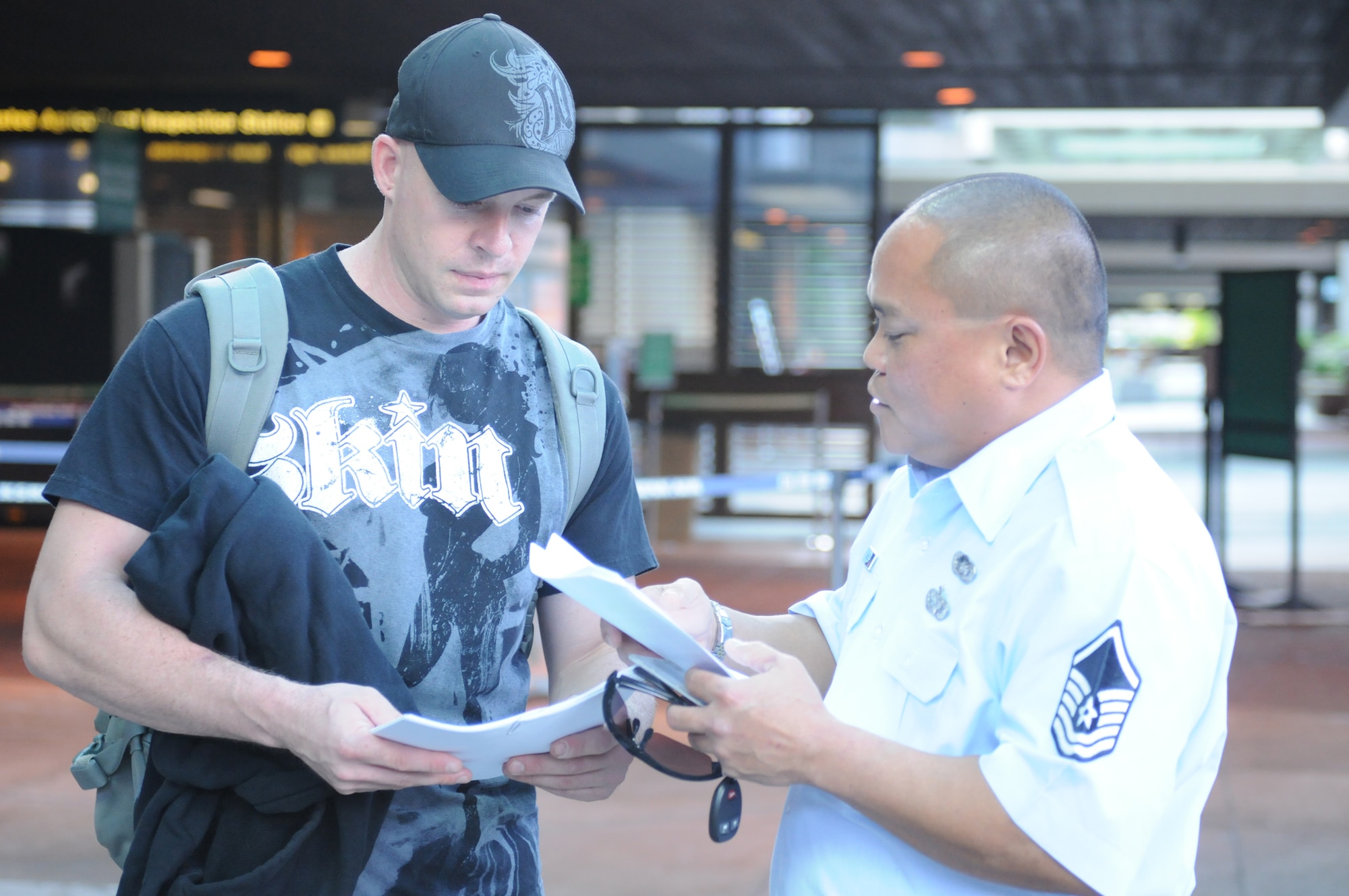 HONOLULU INTERNATIONAL AIRPORT, Hawaii -- U.S. Air Force Reserve Tech. Sgt. Sean Warnet, 48th Aerial Port Sqaudron, 624th Regional Support Group, goes over his orders with Master Sgt. Felemon Torres, 48 APS, before boarding a plane here Jan. 24. Sergeant Warnet is joining other 48 APS servicemembers stationed at Hickam Air Force Base, Hawaii, for an extended deployment to Southwest Asia in support of contingency operations. They will be working alongside other Air Force APS Airmen in conducting ramp operations, processing cargo and passengers. (U.S. Air Force photo/Tech. Sgt. Steve Lewis)