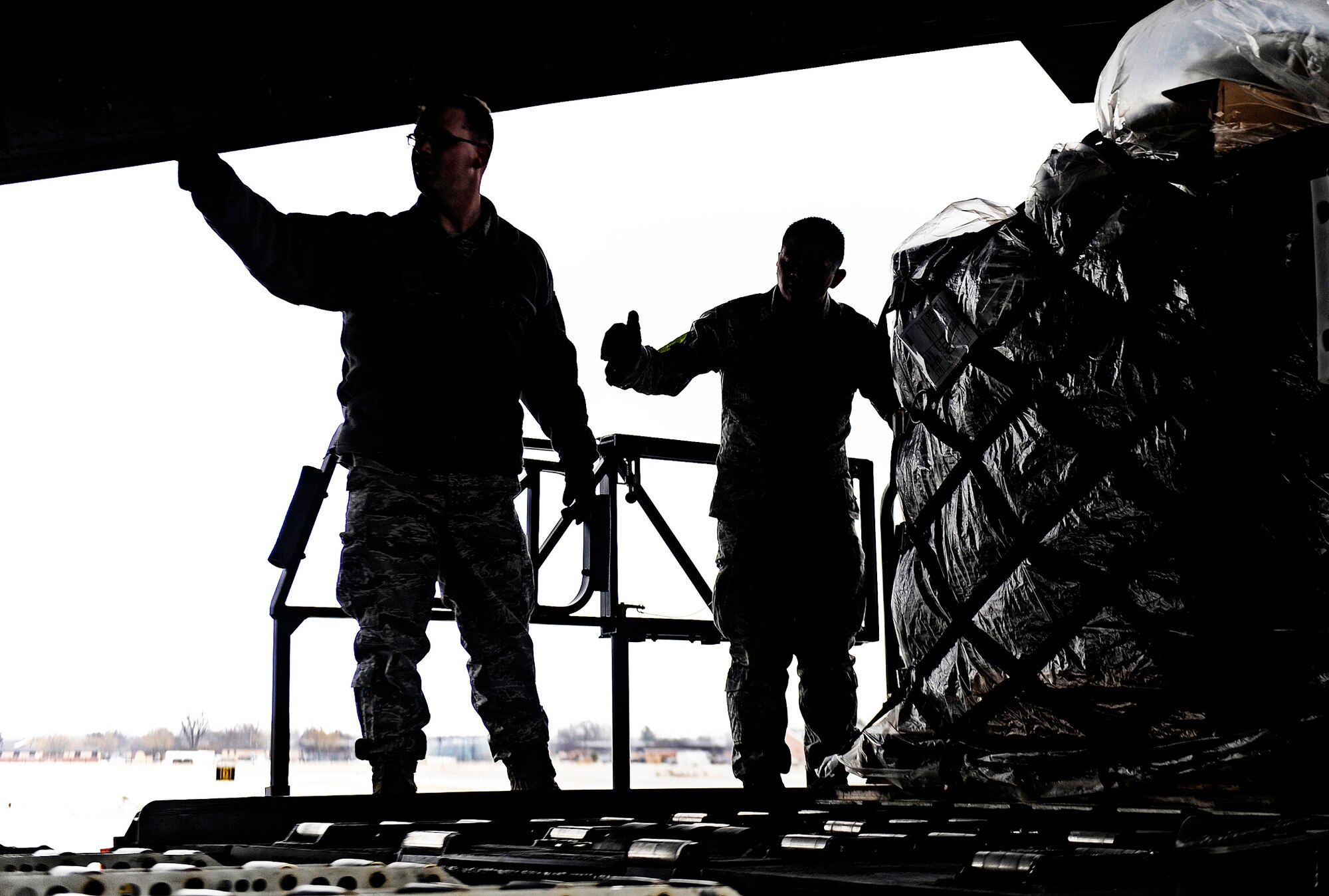 Airmen from the 375th Logistics Readiness Squadron give loadmasters the ‘all clear’ to move the final pallet onto a C-17 Globemaster III Feb. 7, 2011, at Scott Air Force Base, Ill. (U.S. Air Force photo/ Staff Sgt. Ryan Crane)