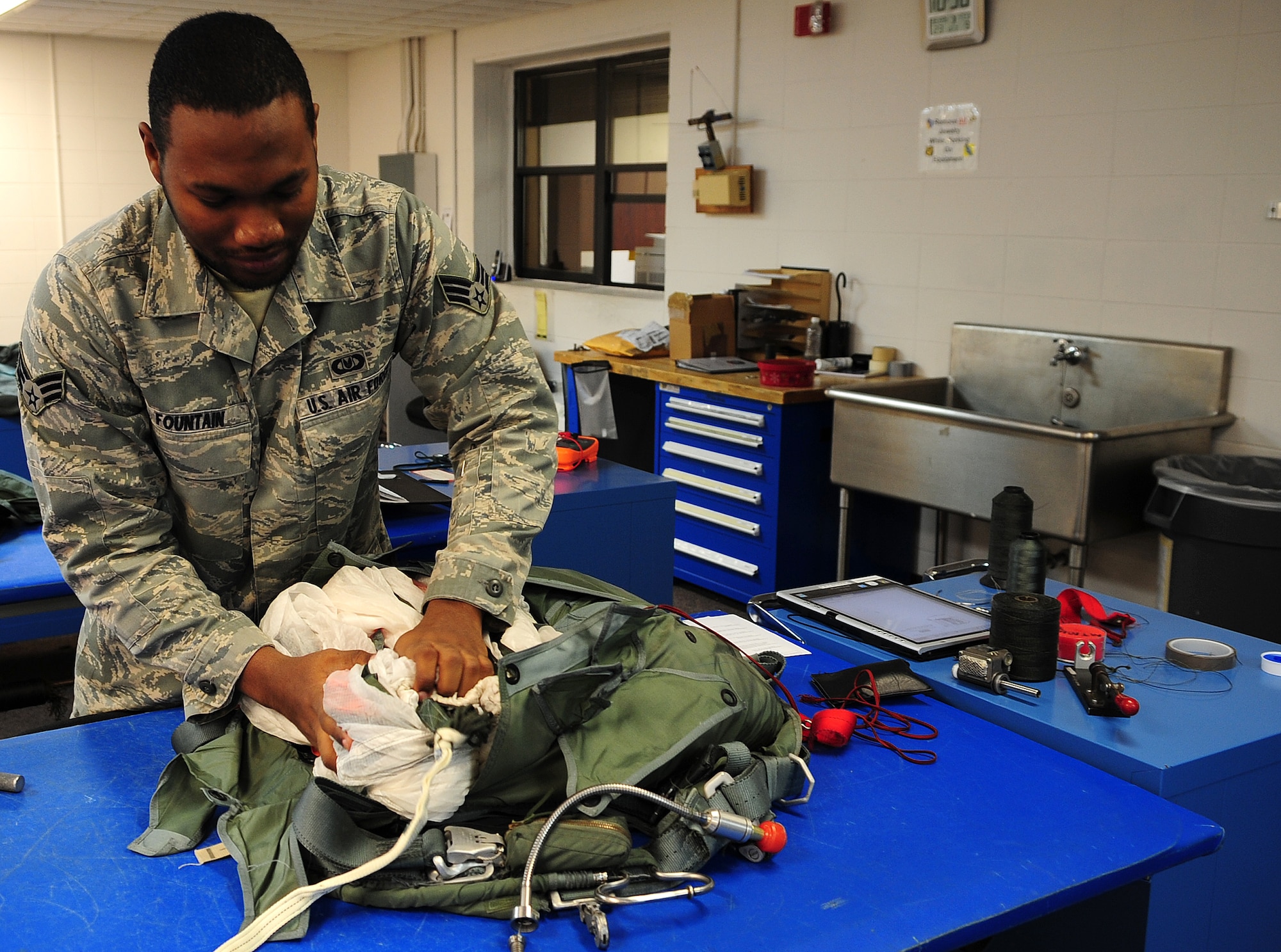 MOODY AIR FORCE BASE, Ga.-- Senior Airman Roderick Fountain, 347th Operations Support Squadron aircrew flight equipment journeyman, packs the last part of the canopy into the parachute harness Feb. 9. The parachute harness is used on HC-130P/N Combat King in case of an emergency. (U.S. Air Force photo/Senior Airman Stephanie Mancha)(RELEASED)