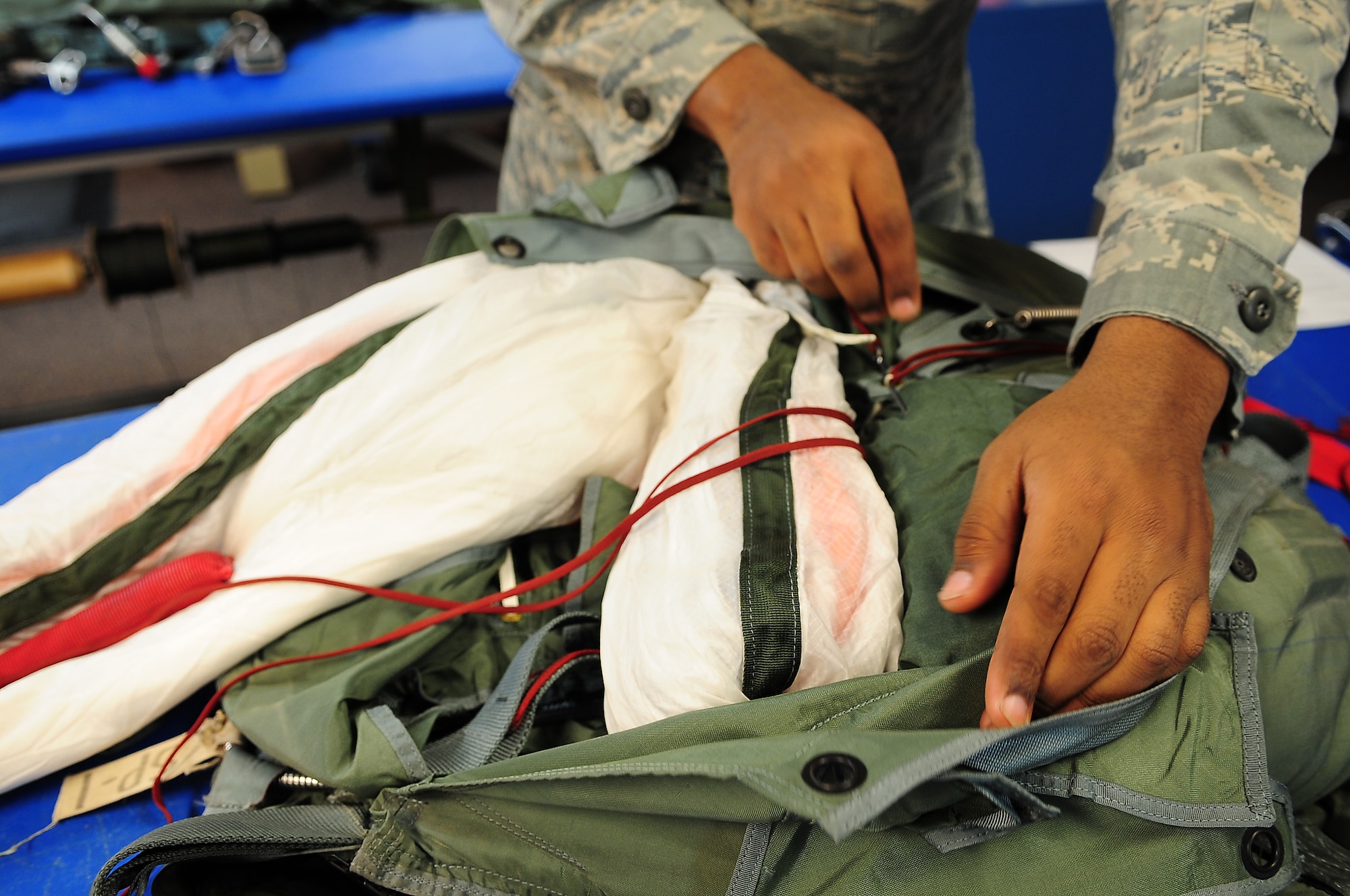 MOODY AIR FORCE BASE, Ga.-- Senior Airman Roderick Fountain, 347th Operations Support Squadron aircrew flight equipment journeyman, ties the canopy strap Feb. 9. This allows there to be a delay before the suspension lines get released from the quarter deployment bag. (U.S. Air Force photo/Senior Airman Stephanie Mancha)(RELEASED)