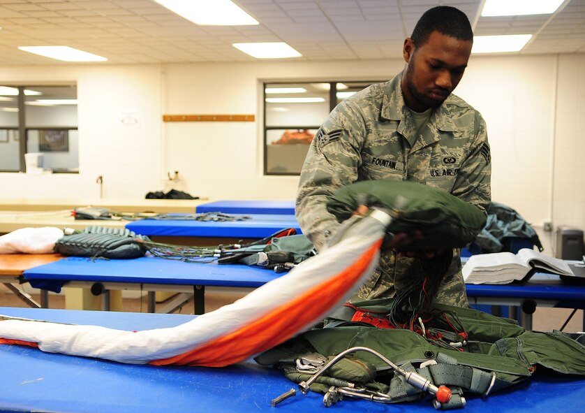 MOODY AIR FORCE BASE, Ga.-- Senior Airman Roderick Fountain, 347th Operations Support Squadron aircrew flight equipment journeyman, places the quarter deployment bag into a parachute harness Feb. 9. The bag is one of many pieces of equipment that ensure the safety of the individual during the deployment of a parachute. (U.S. Air Force photo/Senior Airman Stephanie Mancha)(RELEASED)
