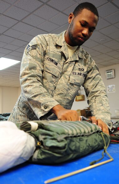 MOODY AIR FORCE BASE, Ga.-- Senior Airman Roderick Fountain, 347th Operations Support Squadron aircrew flight equipment journeyman, stows suspension lines into a quarter deployment bag used to store the parachute lines and canopy Feb. 9. Parachute riggers have the important and life-saving job of ensuring that a parachute is properly equipped. (U.S. Air Force photo/Senior Airman Stephanie Mancha)(RELEASED)