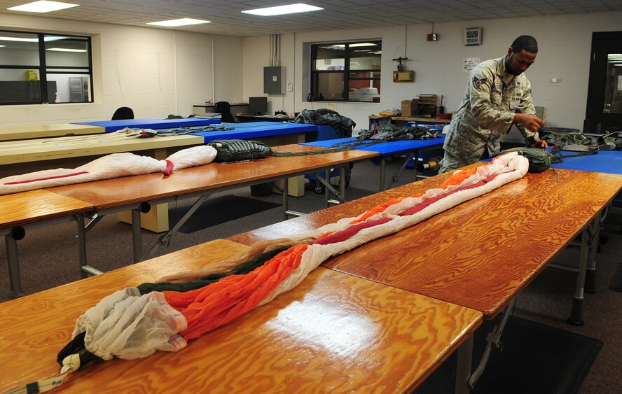 MOODY AIR FORCE BASE, Ga.-- Senior Airman Roderick Fountain, 347th Operations Support Squadron aircrew flight equipment journeyman, stows suspension lines into a quarter deployment bag used to store parachute lines and canopy Feb. 9. The lines attach to the canopy and allow it to deploy smoothly, while the bag helps to keep the parachute lines untangled during deployment. (U.S. Air Force photo/Senior Airman Stephanie Mancha)(RELEASED)
