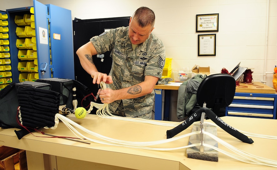 MOODY AIR FORCE BASE, Ga.-- Tech. Sgt. Wade Hurst, 76th Fighter Squadron aircrew flight equipment NCO in charge, stows lines onto the advance concept ejection seat II (ACES II) parachute system for the A-10C Thunderbolt II Feb. 9. "I enjoy my job because this is the first line of getting to the ground and surviving," said Sergeant Hurst. (U.S. Air Force photo/Senior Airman Stephanie Mancha)(RELEASED)