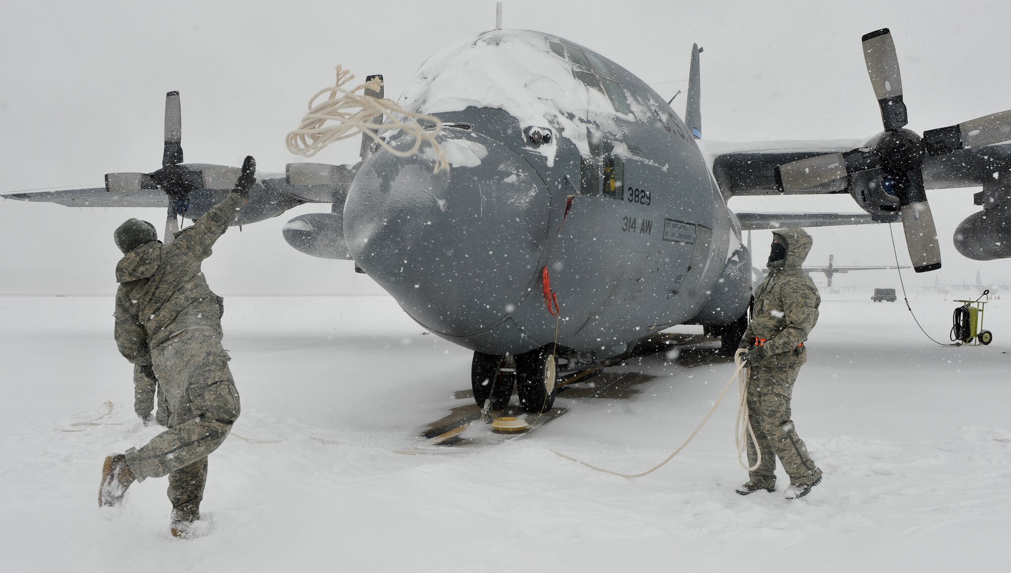 Members of the 19th Aircraft Maintenance Squadron, throw ropes on top of the C-130 Hercules to remove snow from the aircraft on Feb. 9, 2011 at Little Rock Air Force Base, Ark. Maintenance Airmen removed snow from aircraft to expedite the chemical de-icing process. (U.S. Air Force photo by Senior Airman Gul Crockett)