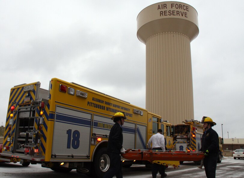 Firemen with the Allegheny County Airport Authority carry a stretcher to the Aircraft Maintenance Squadron’s Fuel Cell Hanger here, during the February Unit Training Assembly, as of part of a fuel cell extraction exercise. The exercise is held every year in preparation for a follow-on inspection, which is scheduled in April this year.