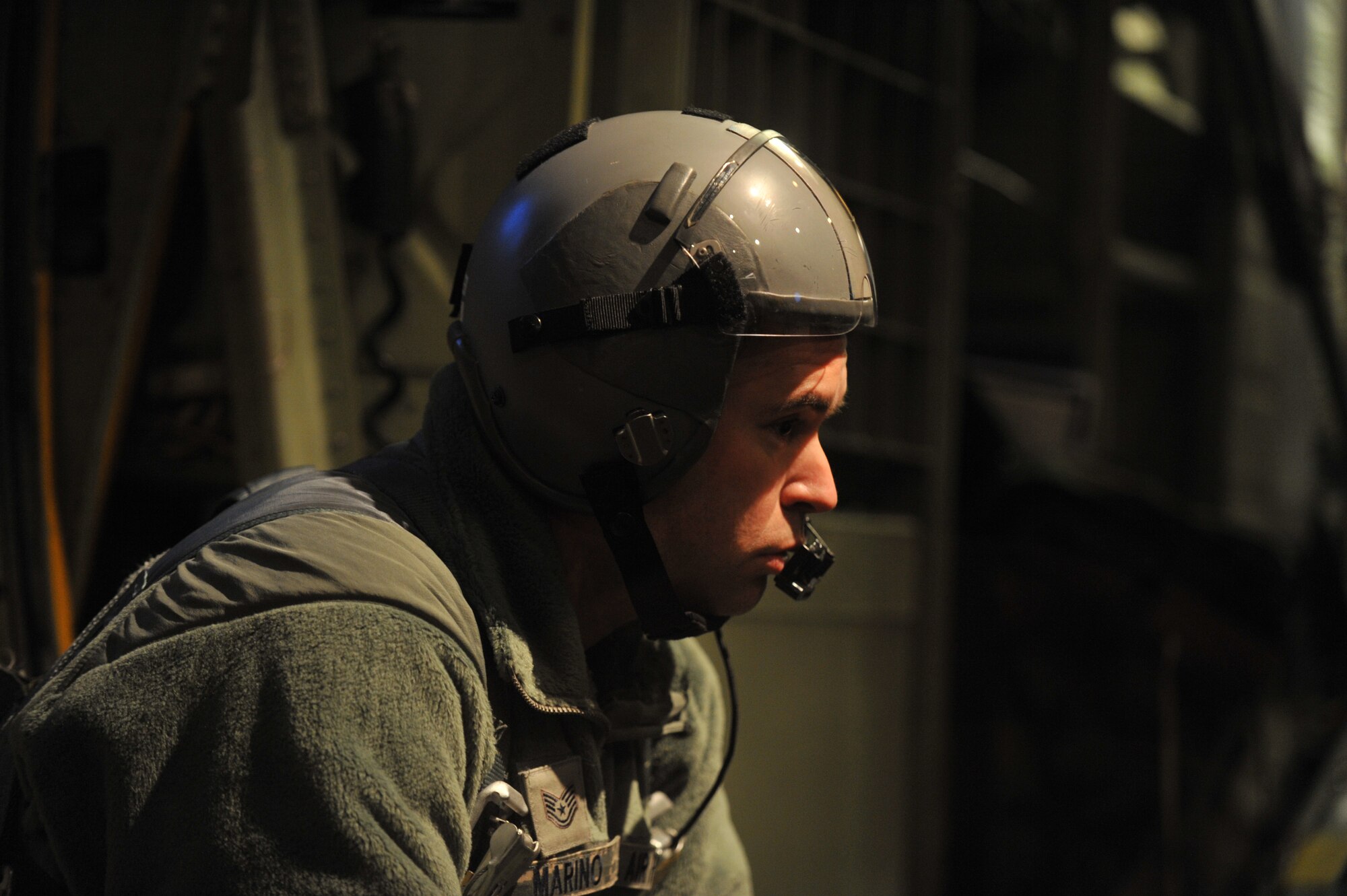 Tech. Sgt. Mark Marino, loadmaster with the 757th Airlift Squadron, waits for a signal to move paratroopers into position to jump out of a 910th Airlift Wing C-130 Hercules during Operation Toy Drop over Fort Bragg, N.C., Dec. 11, 2010. U.S. Air Force photo by Senior Airman Erik Cardenas.