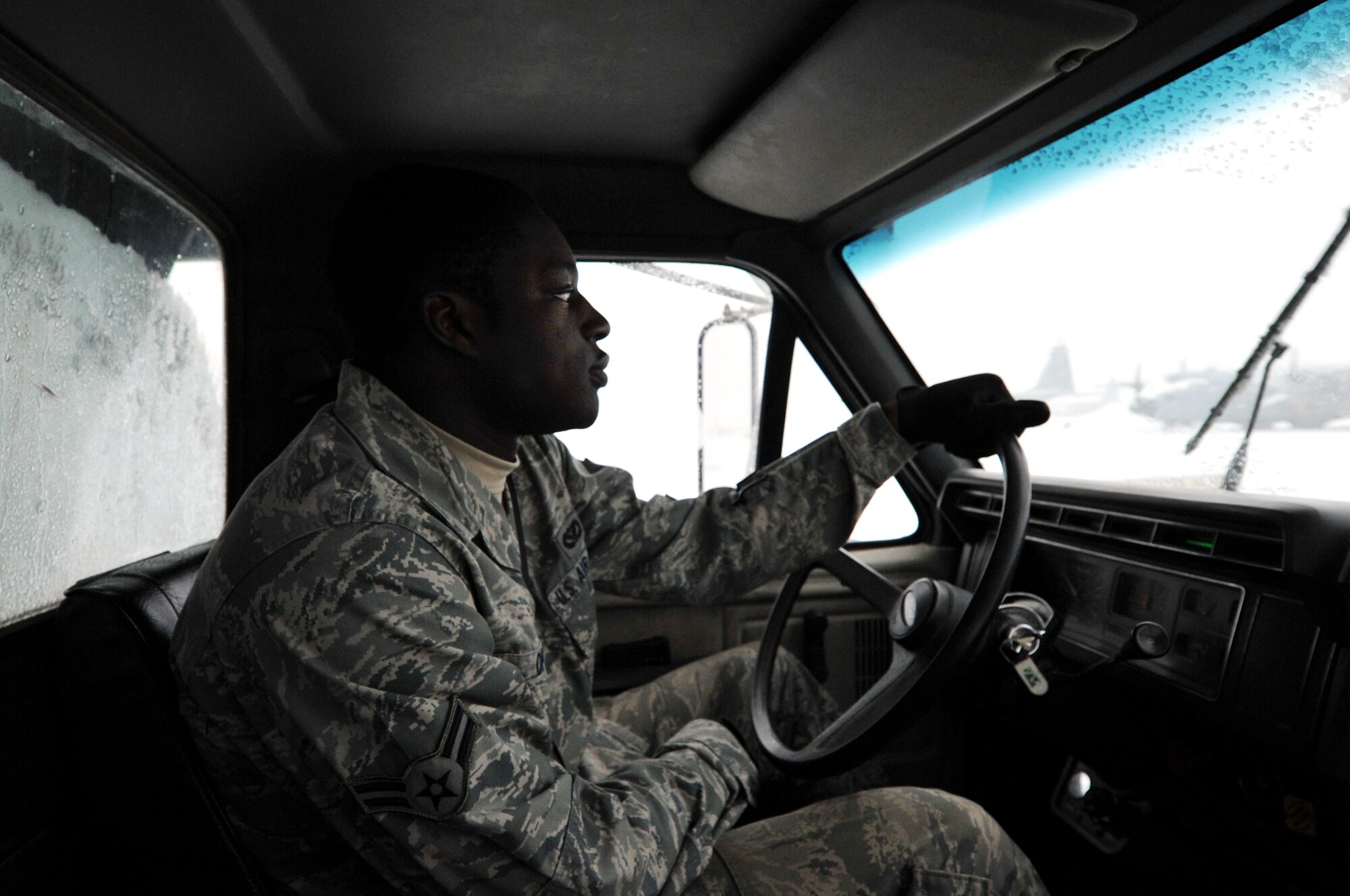 Airman 1st Class Ernie Opoku, a Pavement and Heavy Equipment Apprentice, with the 19th Civil Engineer Squadron, plows the base flight line, at Little Rock Air Force Base, Ark., Feb. 9, 2011. Opoku and the rest of CE worked to keep the flight line clear, during one of the winter snow storms of the month. (U.S. Air Force photo by Airman 1st Class Rusty Frank)