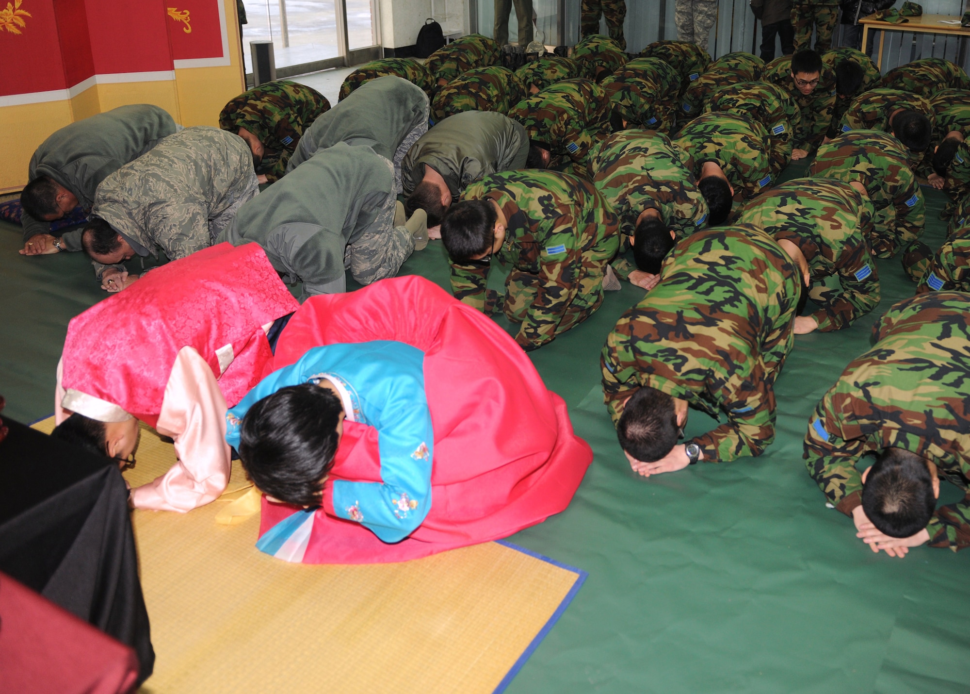 Members of the 8th Fighter Wing and the South Korean air force's 38th Fighter Group begin a memorial service by bowing during a Lunar New Year ceremony Feb. 3, 2011, in the South Korean air force base exchange. The combined 8th FW and South Korean 38th FG ceremony included a memorial service, ceremonial bowing, a traditional Korean breakfast and traditional games. (U.S. Air Force photo/Senior Airman Ciara Wymbs)