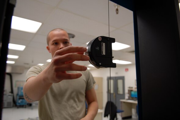 Airman 1st Class Joshua Herman, 412th Maintenance Squadron Precision Measurement Equipment Apprentice, performs a calibration on a cable tensiometer. The cable tensiometer is used to check all mechanical aircraft flight controls. (U.S. Air Force photo/Senior Airman William A. O'Brien) 

