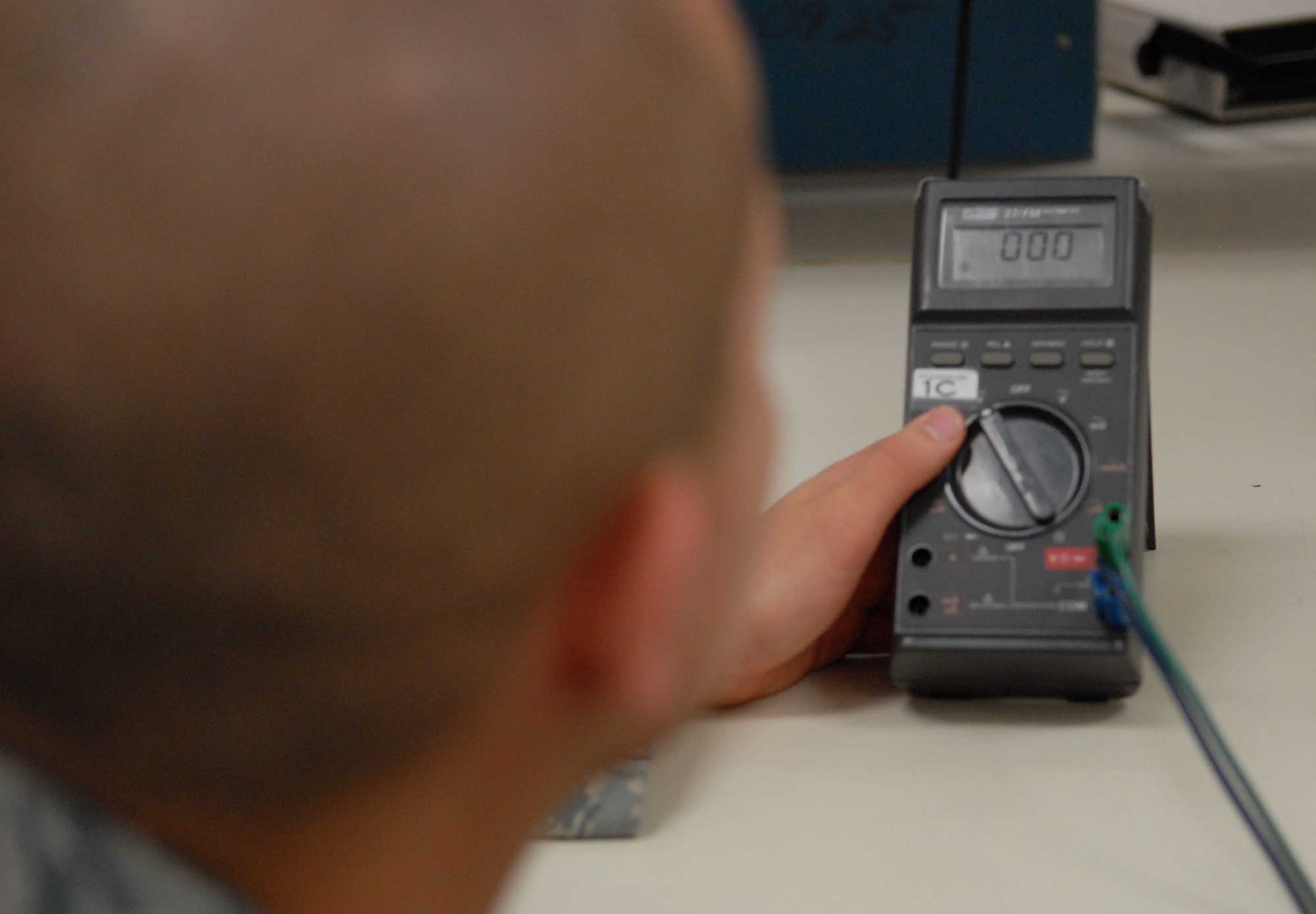 Airman 1st Class Joshua Herman, 412th Maintenance Squadron Precision Measurement Equipment Apprentice, makes a quantitative Direct Current voltage measurement on a handheld digital multi-meter. During the inspection of his flawless calibration process, Joshua received an Air Force Metrology and Calibration coin from the lead auditor. (Air Force photo by Senior Airman William A. O?Brien)