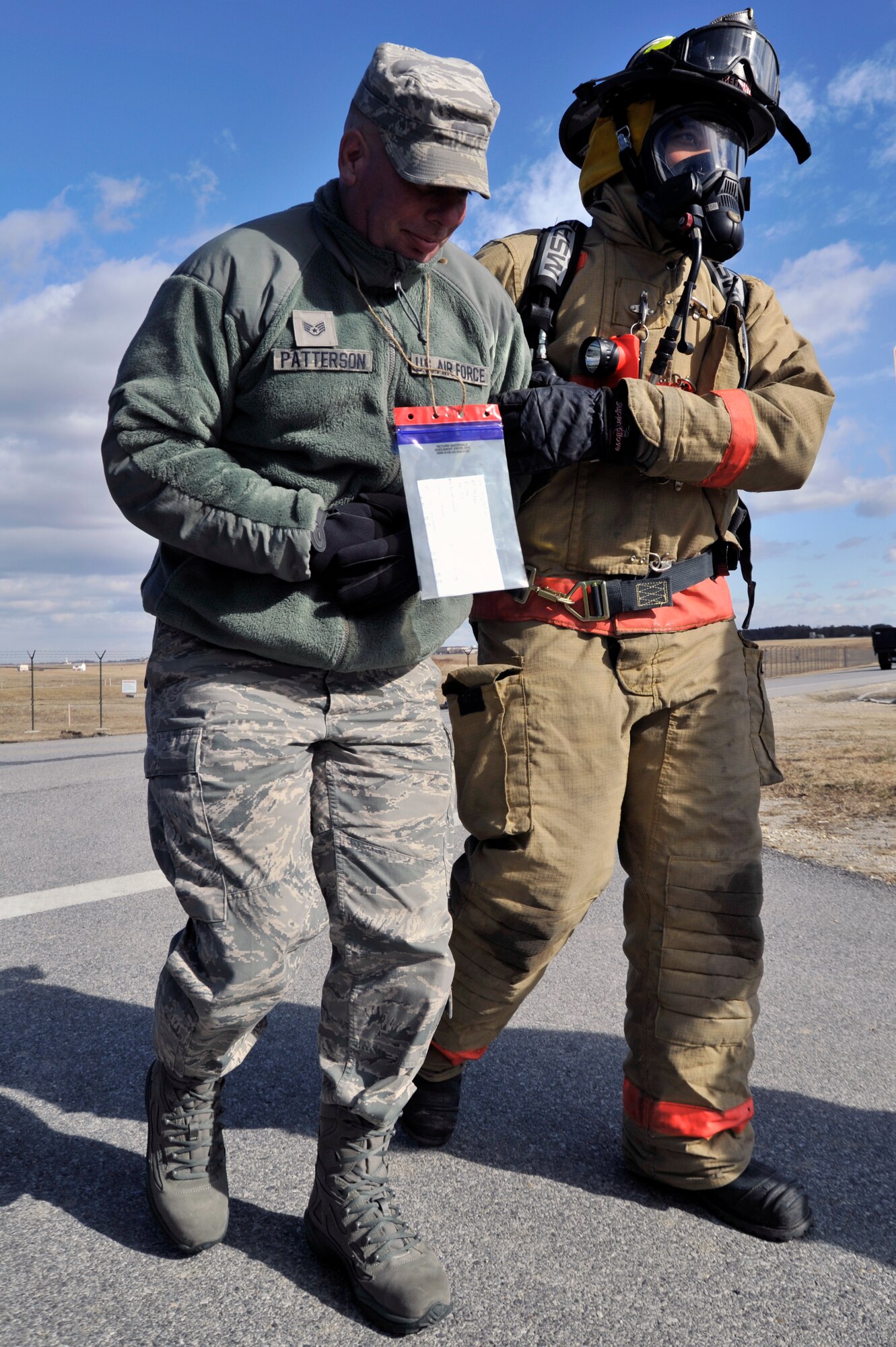 An 11th Civil Engineer Squadron firefighter helps a simulated victim walk to safety during a emergency exercise, Feb. 8, at Joint Base Andrews. Personnel all over Joint Base Andrews participated in the exercise which consisted of a fuel truck crashing into a bus carrying passengers. The exercise was conducted to test the emergency response actions of the installation’s first responders as well as prepare Joint Base Andrews for the upcoming Compliance Inspection.  (U.S. Air Force photo/ Senior Airman Perry Aston)