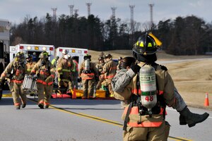 An 11th Civil Engineer Squadron firefighter carries a simulated victim to safety during an emergency exercise, Feb. 8, at Joint Base Andrews. Personnel all over Joint Base Andrews participated in the exercise which consisted of a fuel truck crashing into a bus carrying passengers. The exercise was conducted to test the emergency response actions of the installation’s first responders as well as prepare Joint Base Andrews for the upcoming Compliance Inspection.  (U.S. Air Force photo/ Senior Airman Perry Aston)