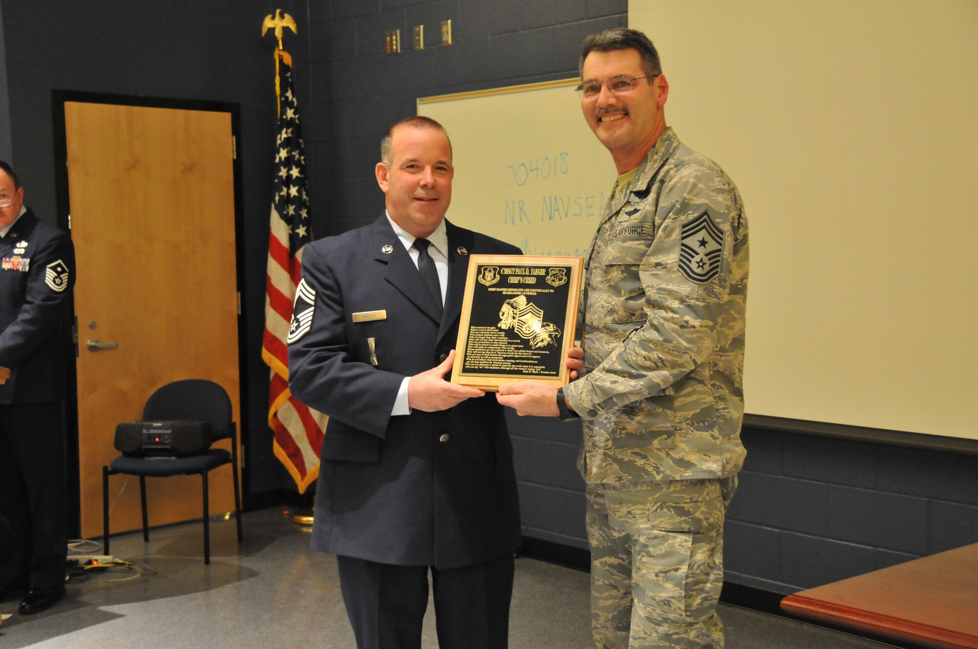 Chief Master Sgt. Mark Koenig, 934th Airlift Wing command chief (right) presents the Chief's Creed plaque to the 934th Airlift Wing's newest Chief Master Sergeant Paul Yeager at the NCO recognition ceremony Jan. 5. (Air Force Photo/Tech. Sgt. Bob Sommer)