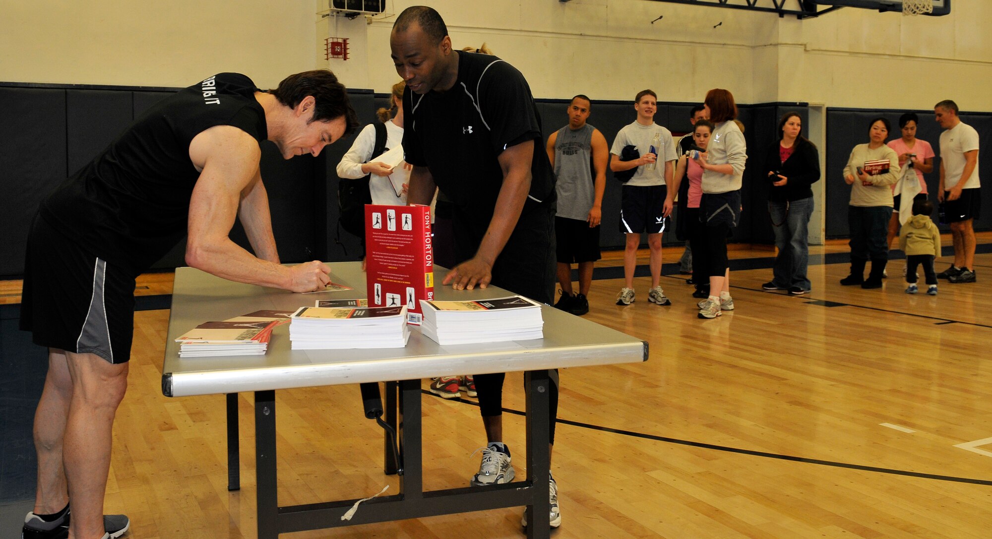 Tony Horton, founder of the P90X exercise routine, signs pictures after a class he taught during his visit to Misawa Air Base, Japan, Feb. 9, 2011. Misawa was the ninth and final stop during his fitness tour of the Pacific region. (U.S. Air Force photo by Tech. Sgt. Phillip Butterfield/Released)  