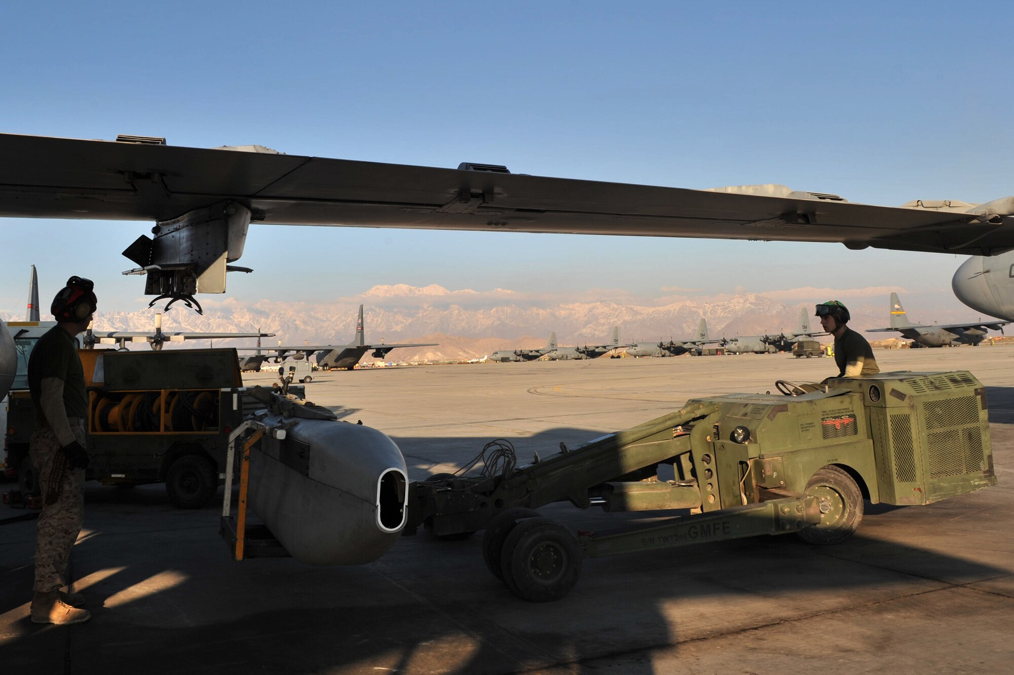 Lance Cpl. Edward Helmick an aviation ordnance technician, guides Lance Cpl. Robert Starmer an electronic countermeasure technician, while installing an ALQ-99 Tactical Jamming System on an EA-6B Prowler electronic warfare aircraft at Bagram Airfield, Afghanistan, Feb. 8, 2011. Corporals Helmick and Starmer are assigned to Marine Tactical Electronic Warfare Squadron 3. (Air Force photo by Senior Airman Sheila deVera)