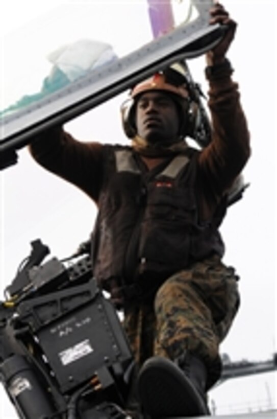 U.S. Marine Corps Cpl. Shannon Tyler, assigned to Marine Fighter Attack Squadron 323, cleans the canopy of an F/A-18C Hornet aircraft on the flight deck of the aircraft carrier USS Ronald Reagan (CVN 76) in the Pacific Ocean on Feb. 5, 2011.  The Ronald Reagan is underway conducting joint task force exercises prior to deploying to the western Pacific Ocean and U.S. Central Command areas of operation.  